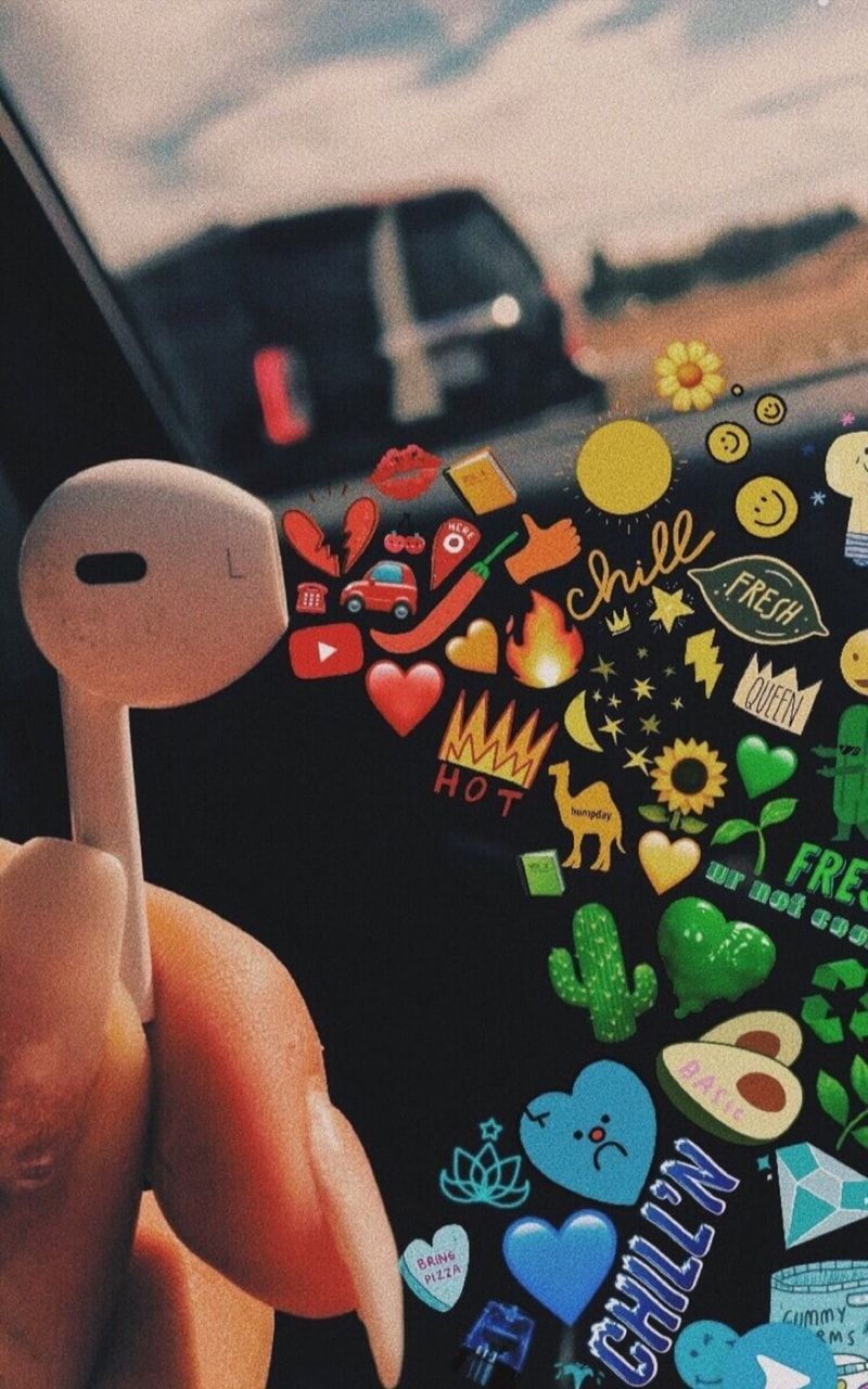 A person holding an apple earphone with stickers on it - VSCO, music