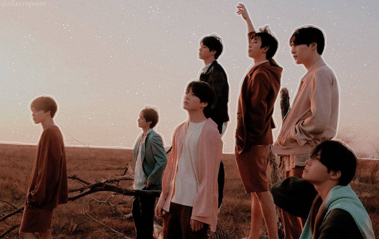 The seven members of BTS stand in a field, looking up at the sky. - BTS