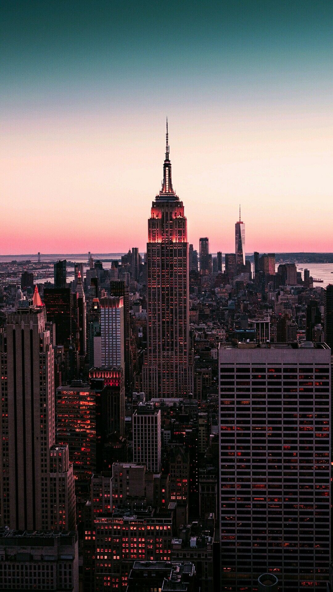 A city skyline at dusk with the empire state building in it - City