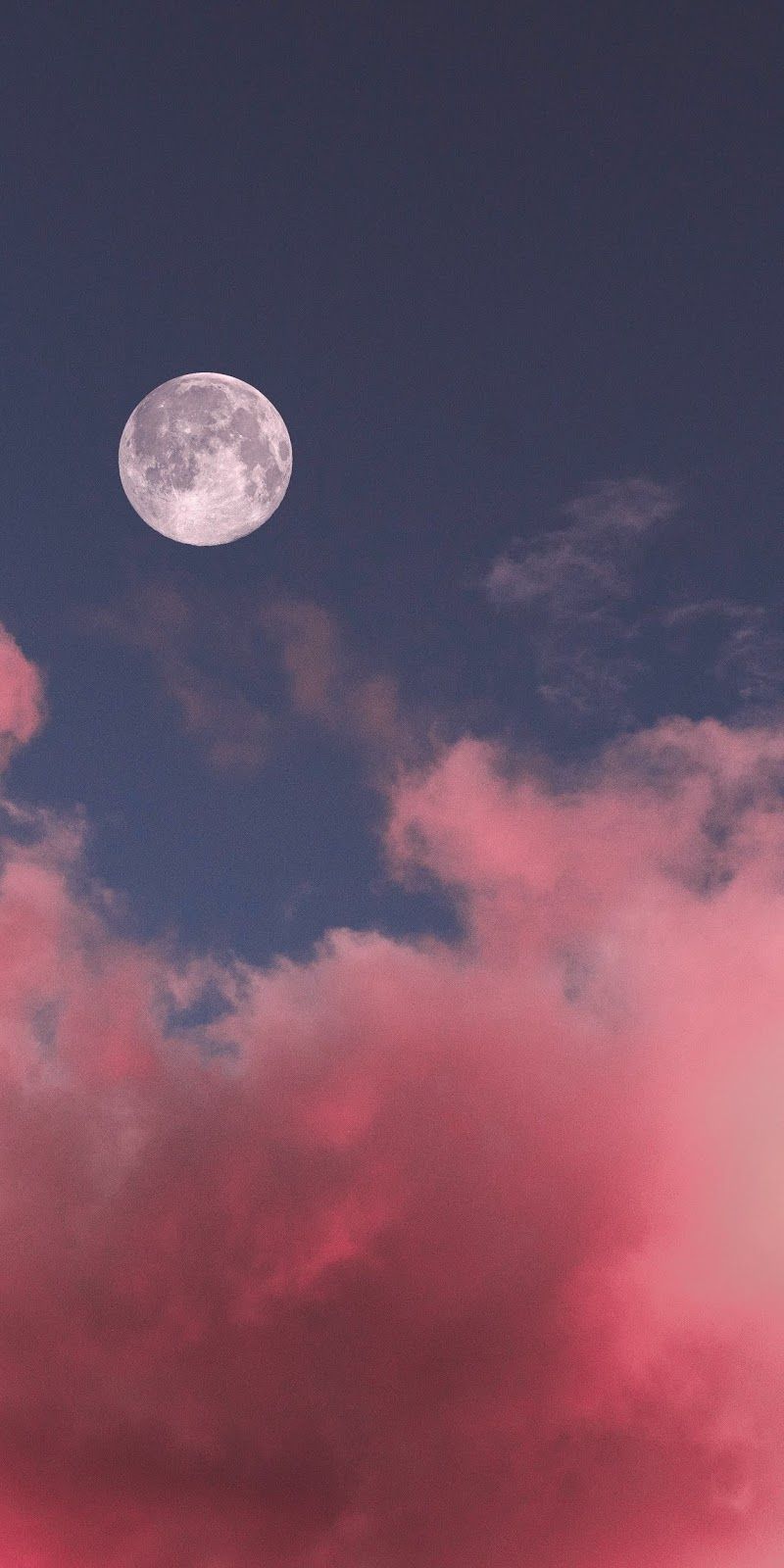 A plane flying over the moon in pink clouds - Moon