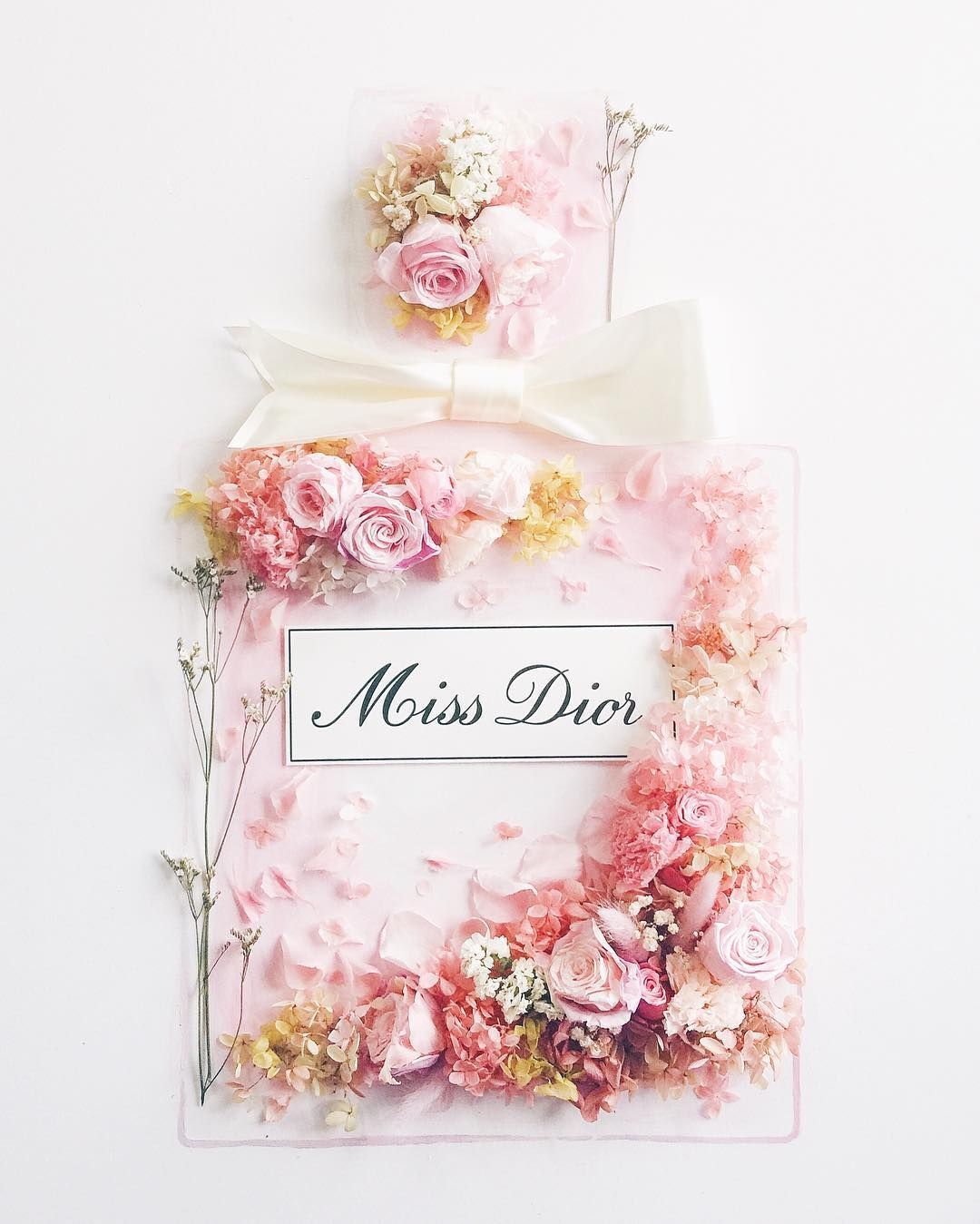 A white bow is placed on top of a Miss Dior bag. - Dior