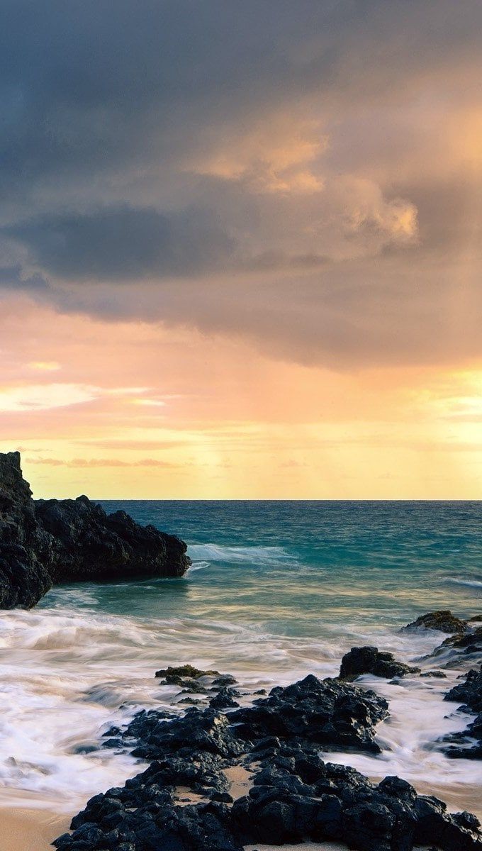 A beach with rocks and water at sunset - Hawaii