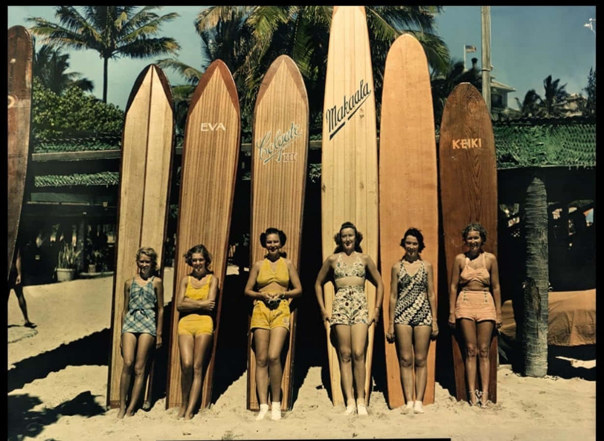 A group of women standing next to surfboards - Surf