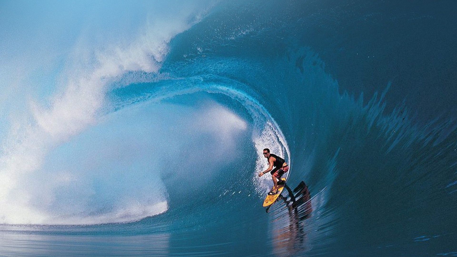 A surfer rides a wave in Hawaii. - Surf