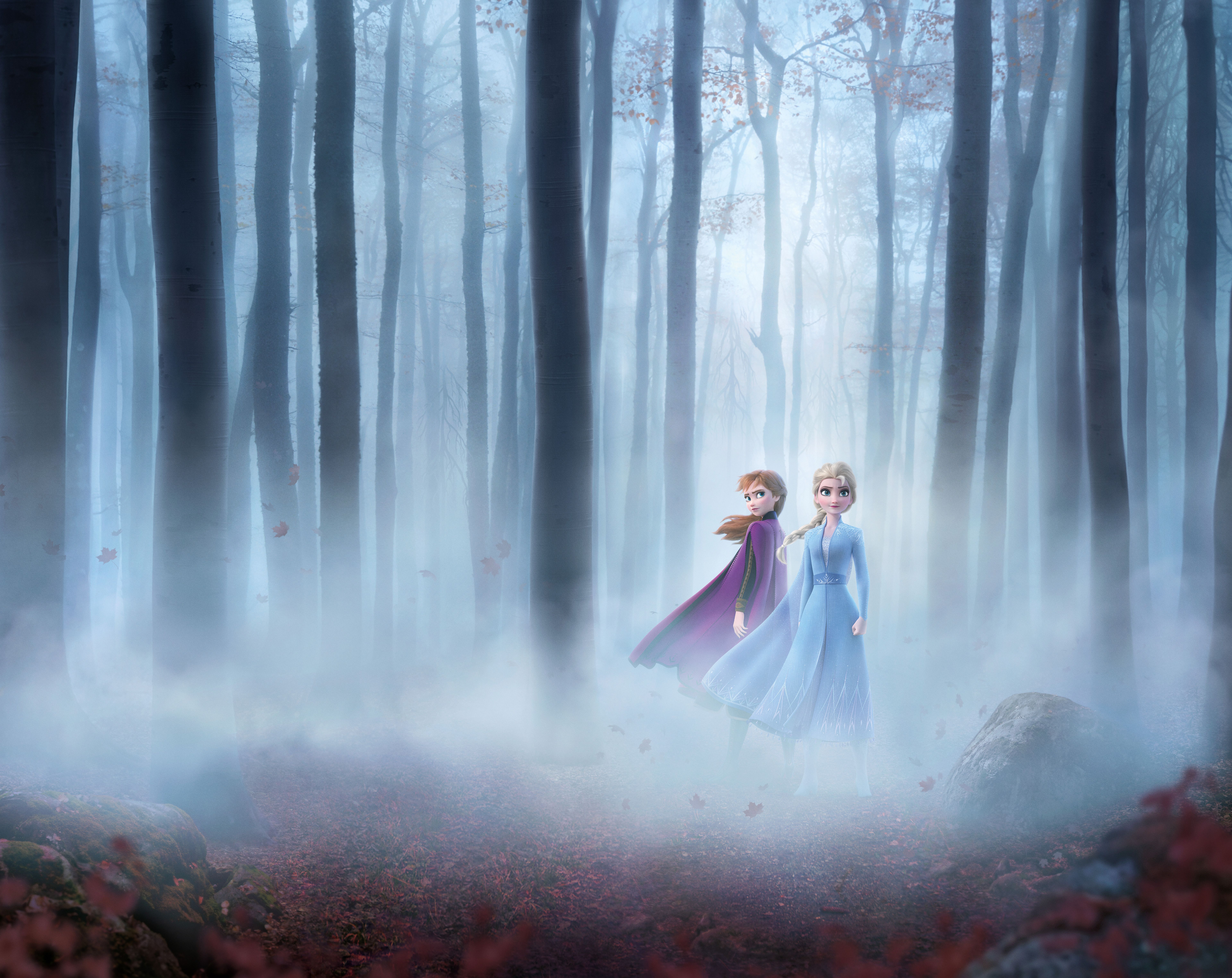 Two people dressed in princess dresses walking through a forest - Elsa