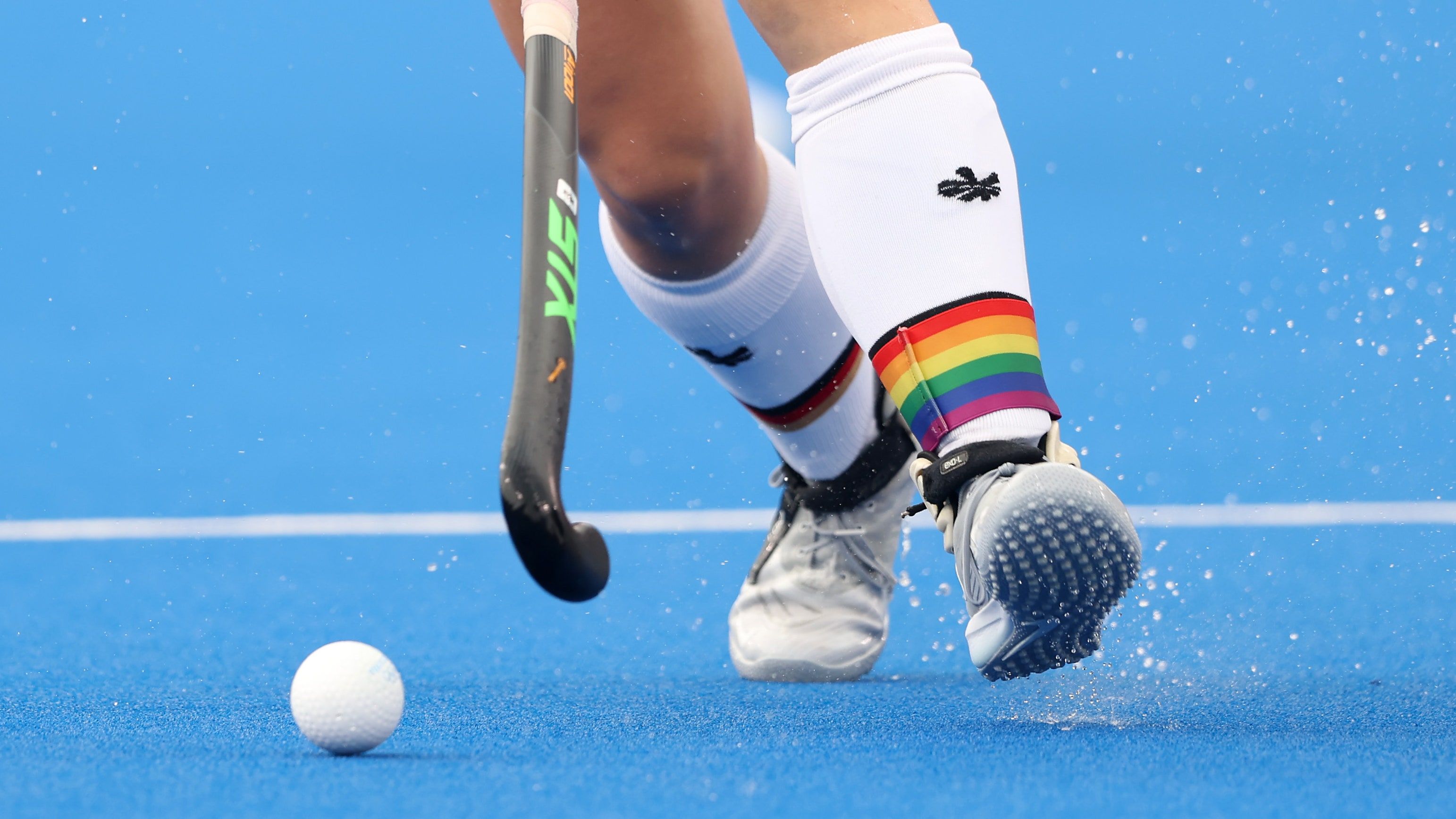 A person playing hockey on the field - Tennis