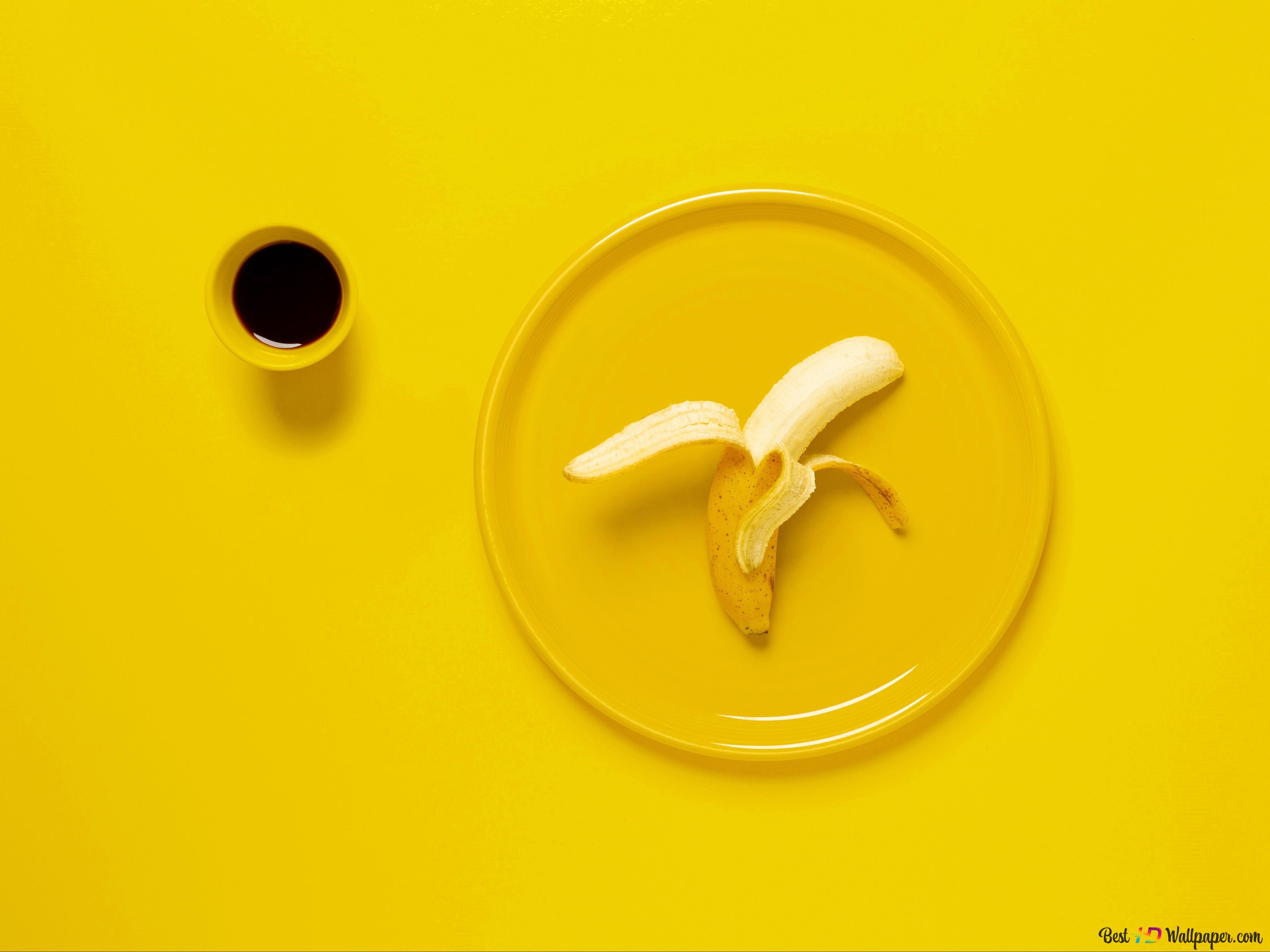 A banana peel on a yellow plate on a yellow table. - Banana