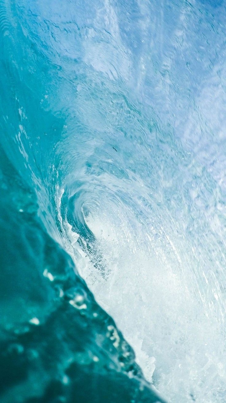 A wave in the ocean with the water inside it blue - Calming