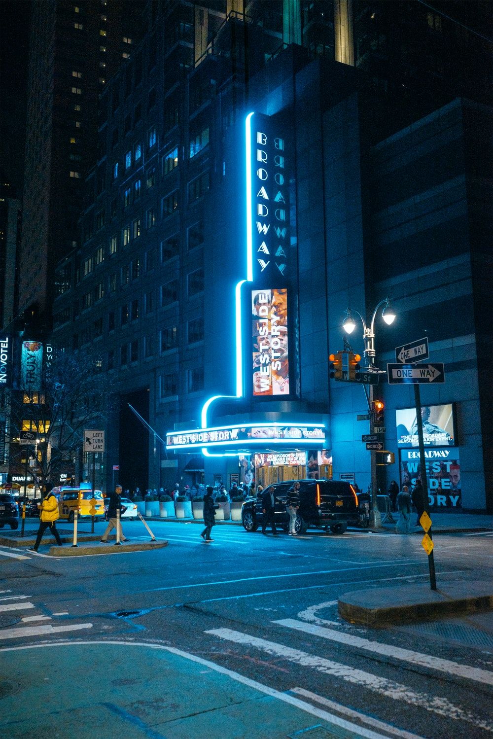 A blue neon sign that says Broadway on a building - Broadway