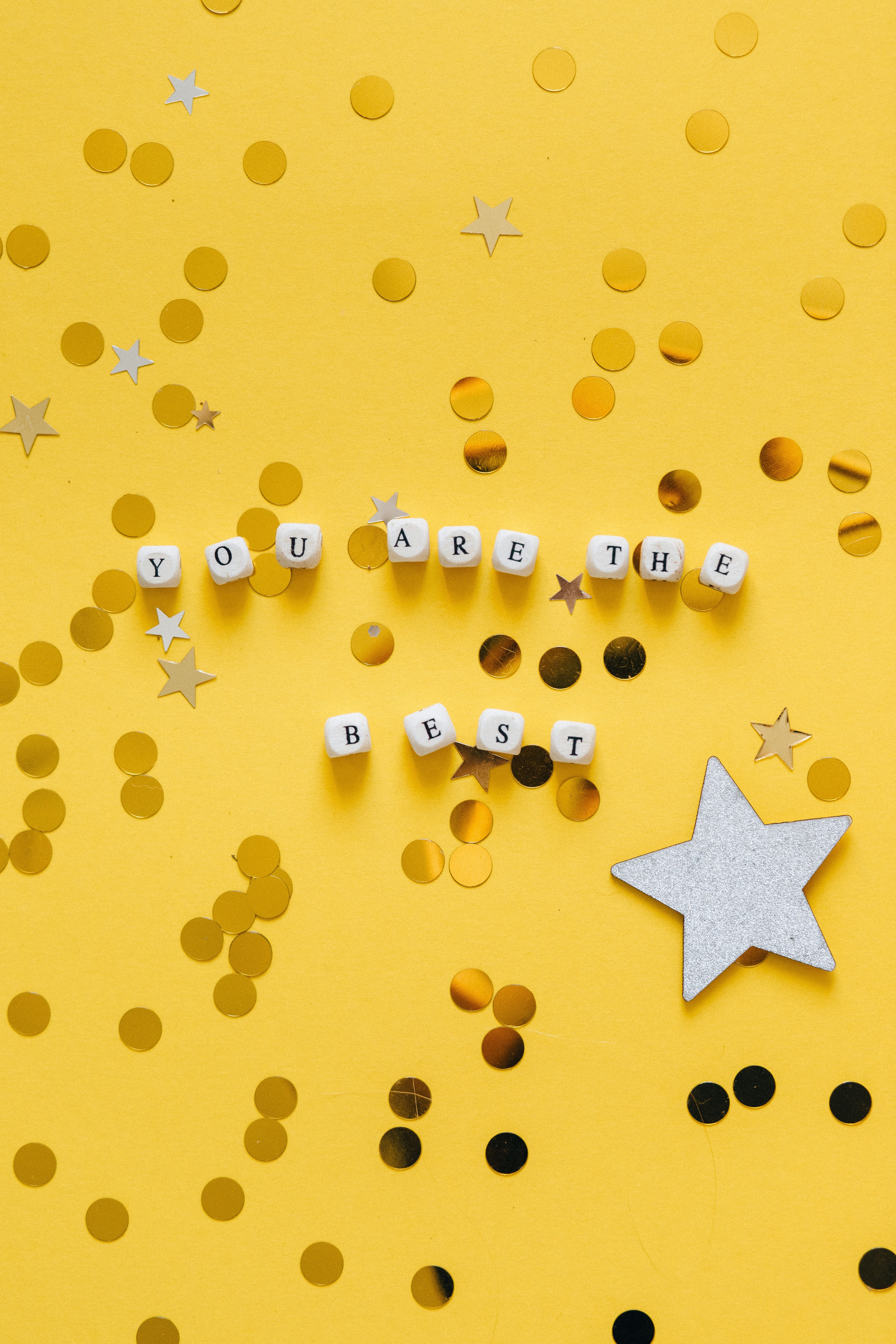 A yellow background with white letters and stars - Emoji