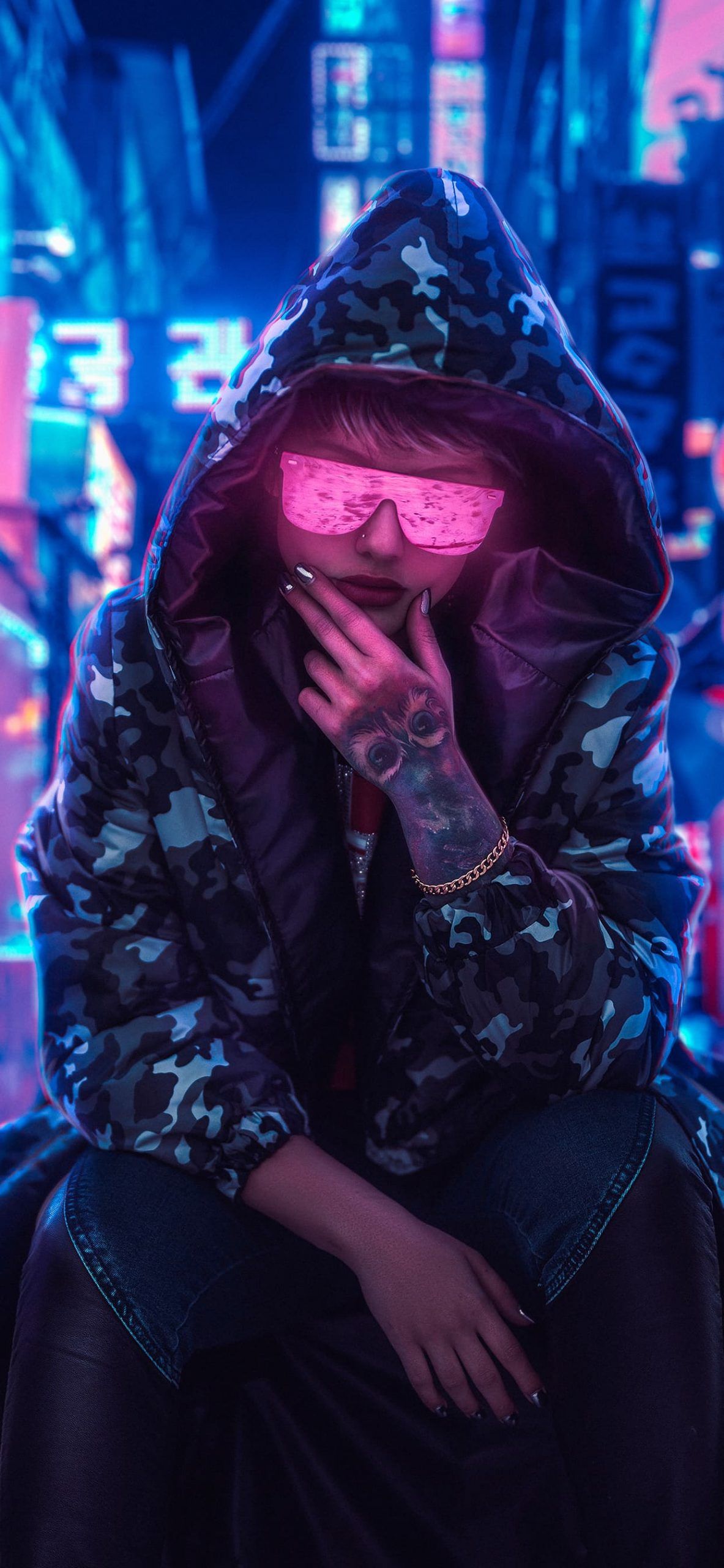 A woman with pink glasses and a camo jacket in a city at night - HD