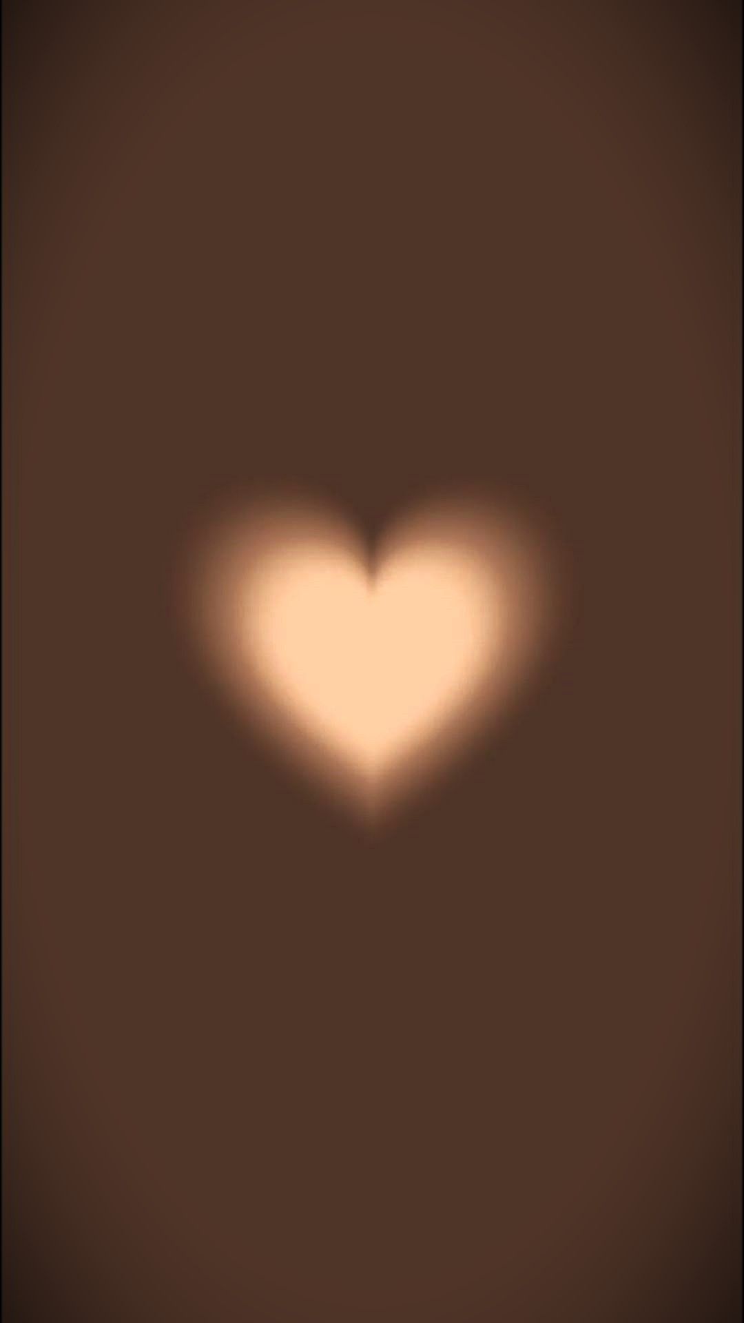 A heart shaped light is shown on the wall - Brown