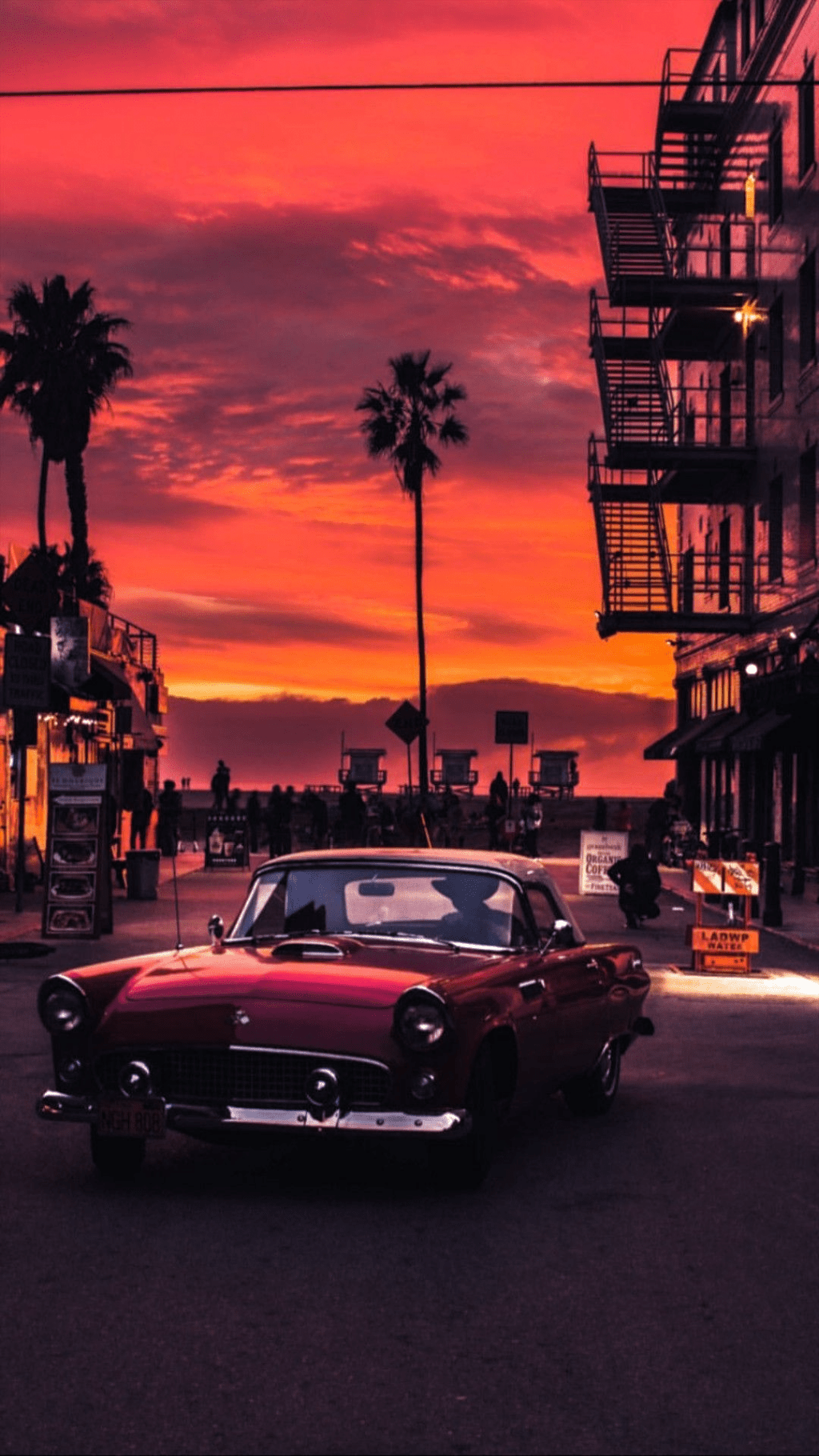 A red car parked on the street at sunset - Cars