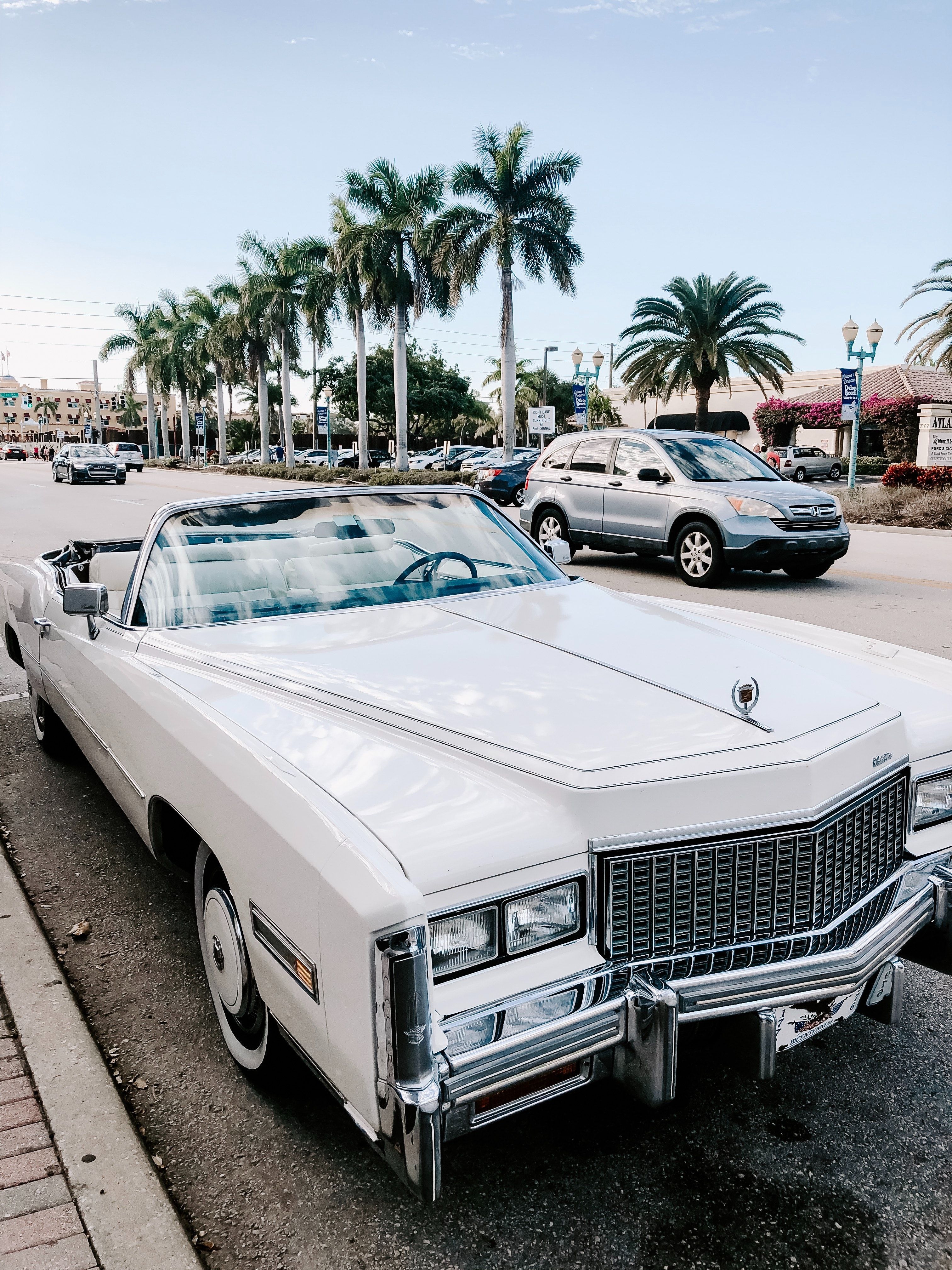 A white classic car parked on the side of the road - Cars