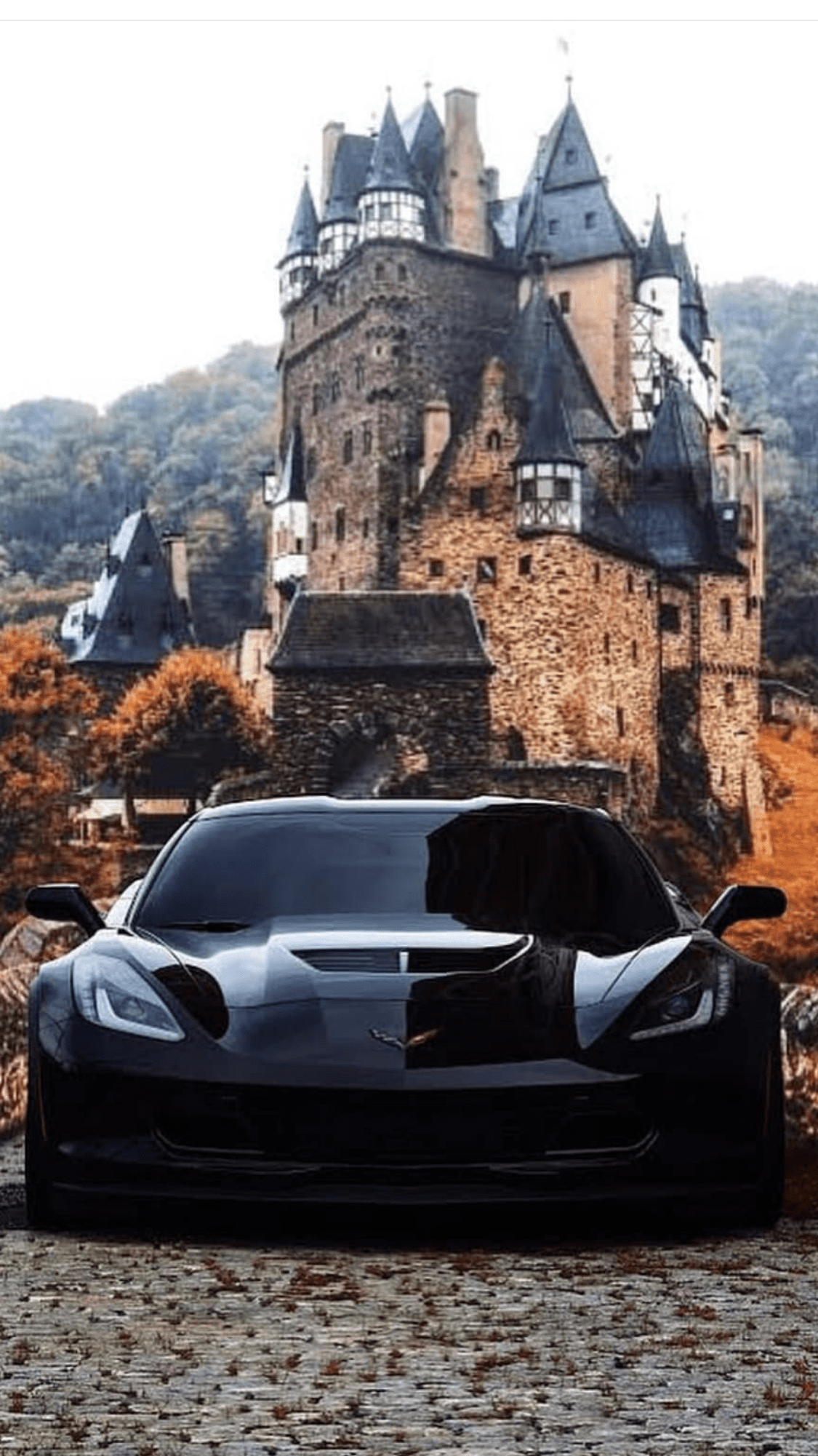 A corvette sports car parked in front of a castle. - Cars