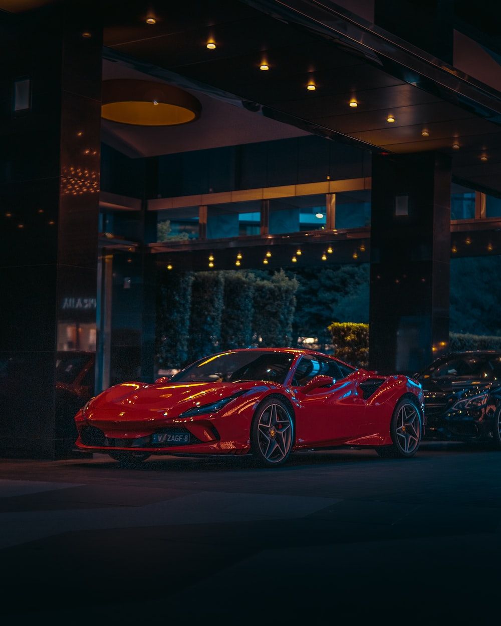 A red sports car parked in front of a building - Cars