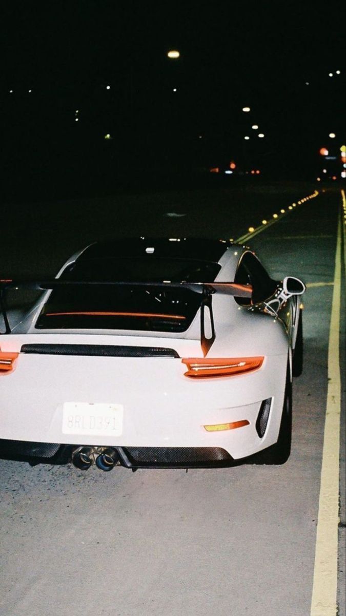 A white sports car with a black roof and a black Lamborghini on the side. - Cars