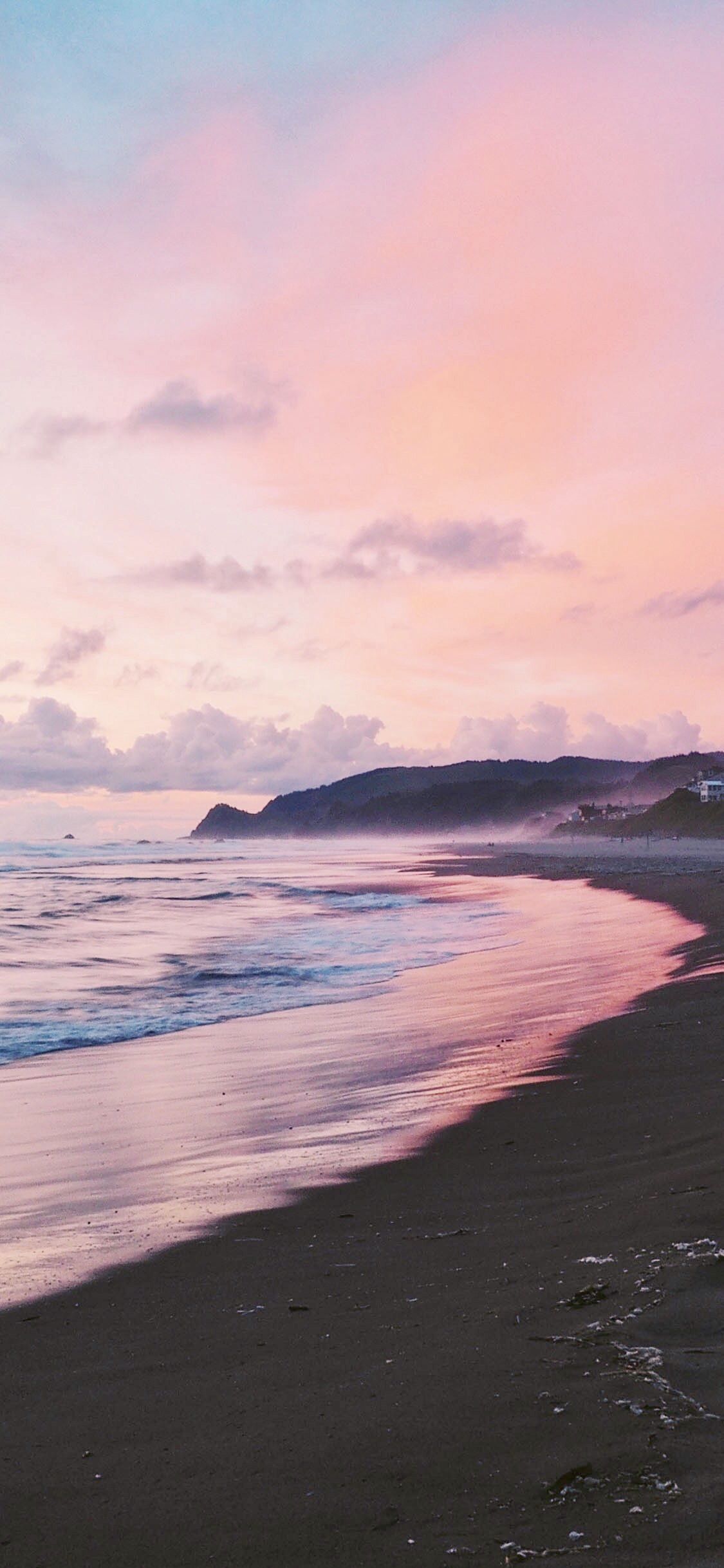 A beach with a pink and blue sunset. - Beach