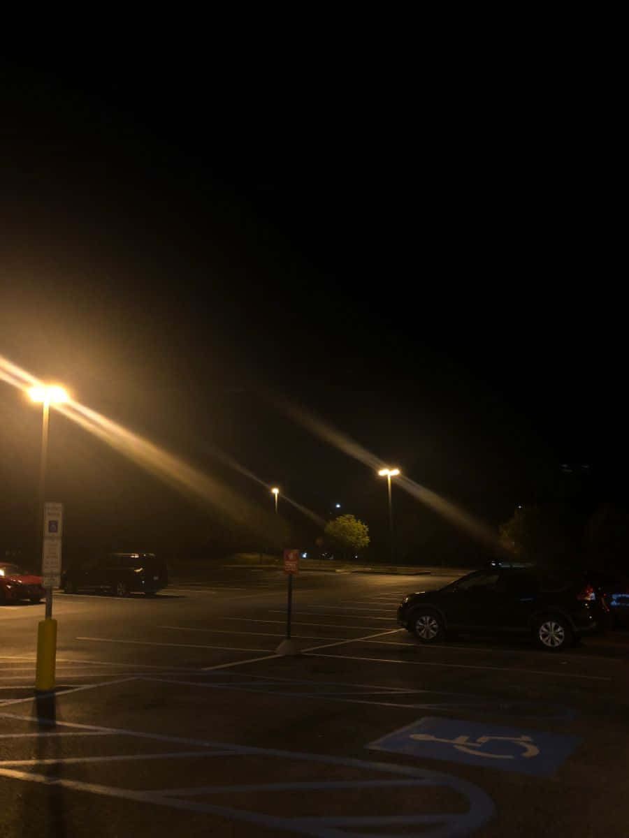 A parking lot with cars and lights - Night