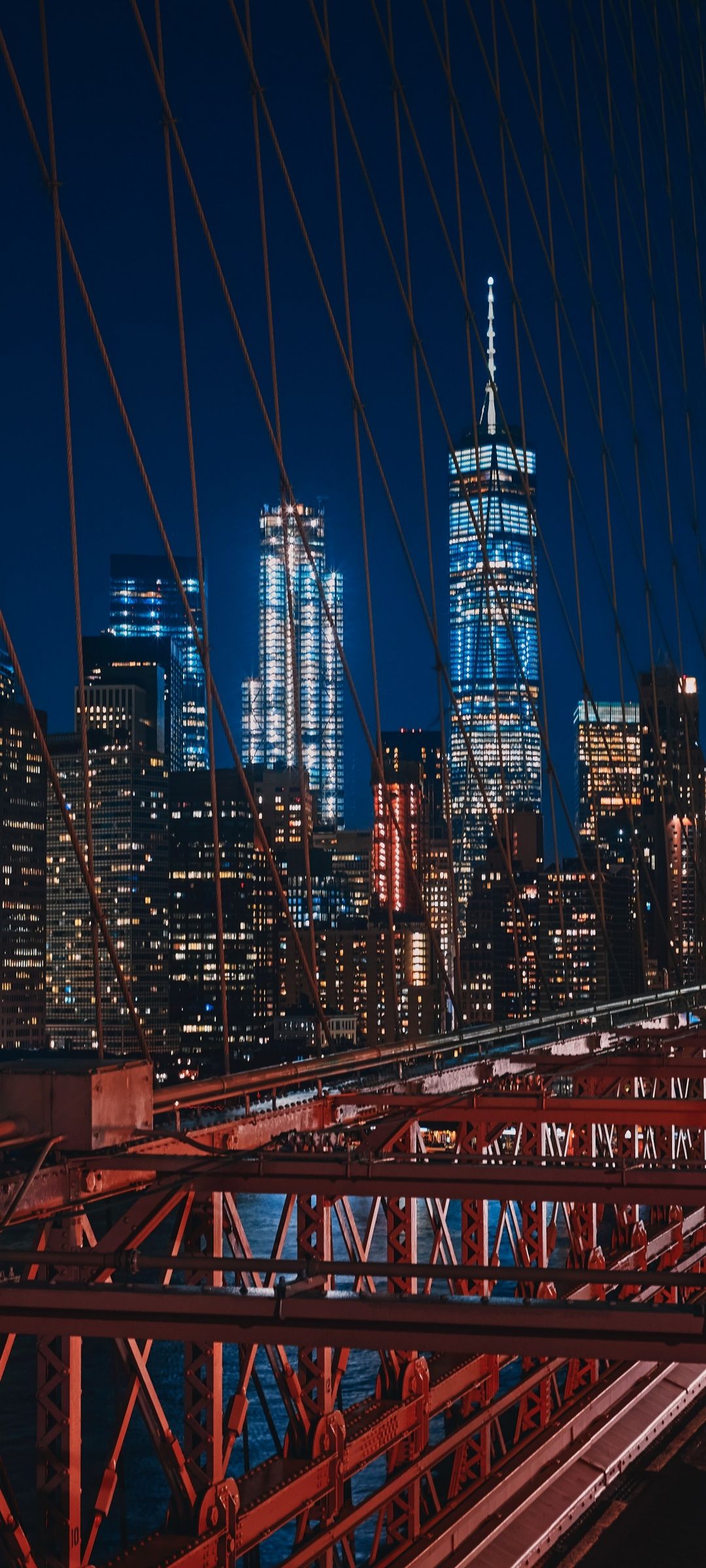 A photo of the Brooklyn Bridge with the city lights of Manhattan in the background - New York