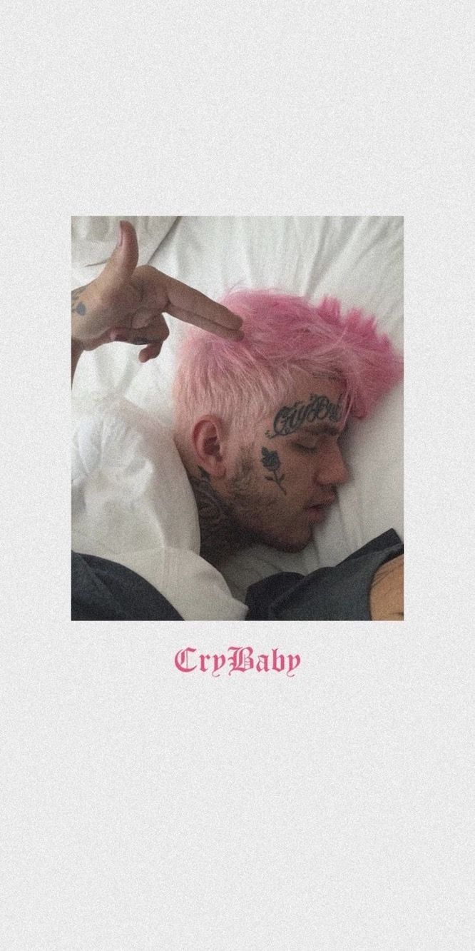 Aesthetic phone wallpaper of a man with pink hair and tattoos laying in bed with the caption 