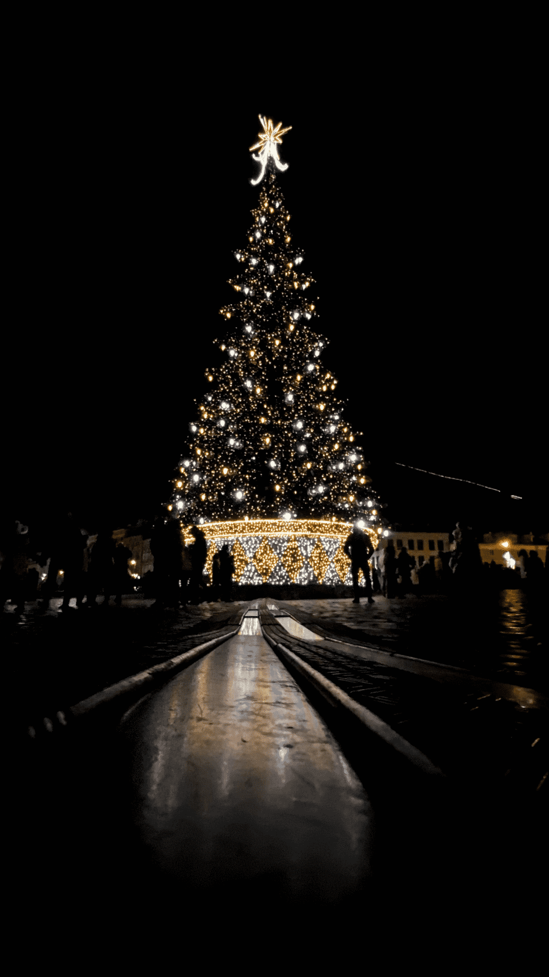 A christmas tree with lights and people around it - December, Christmas, magic, warm, Christmas lights