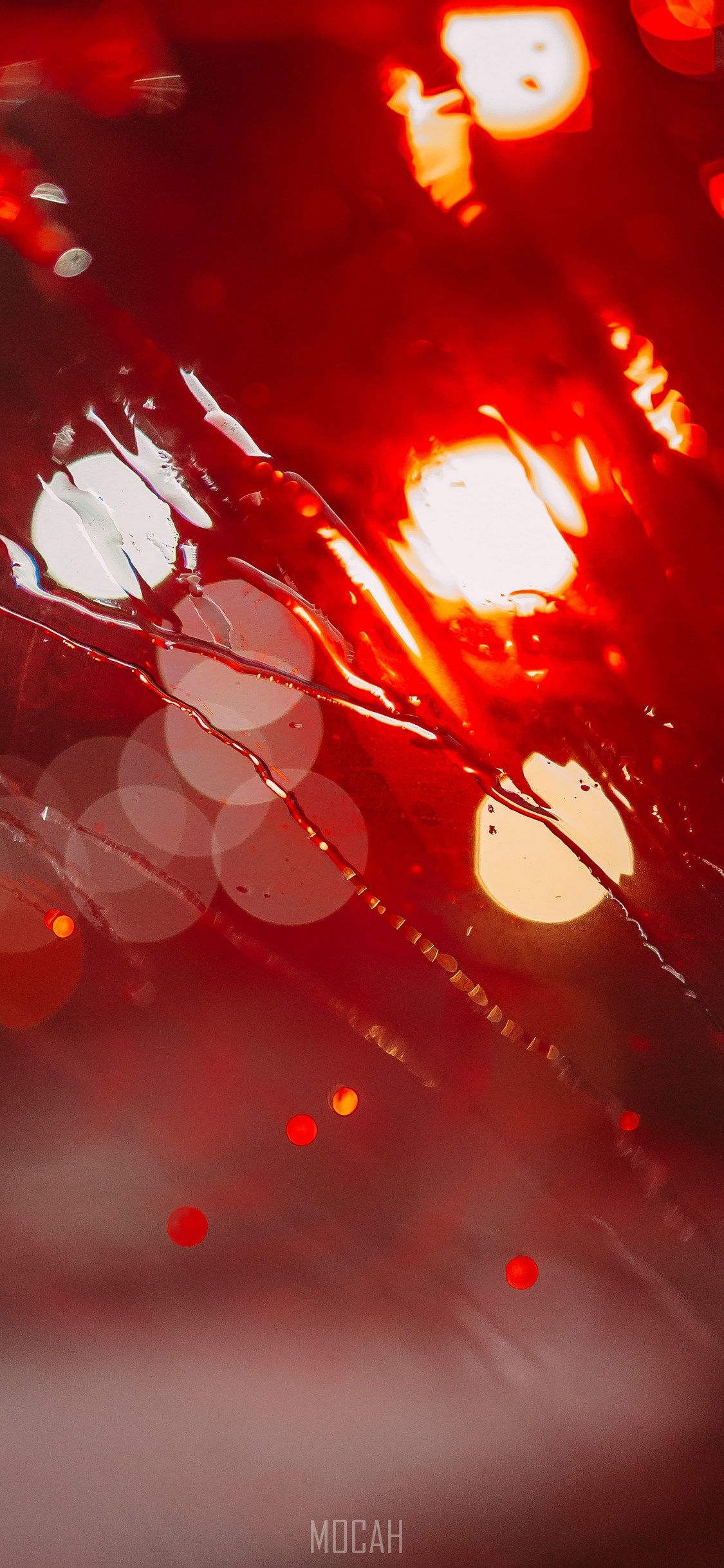 A red car is seen through a rain-streaked windshield. - Blurry, light red