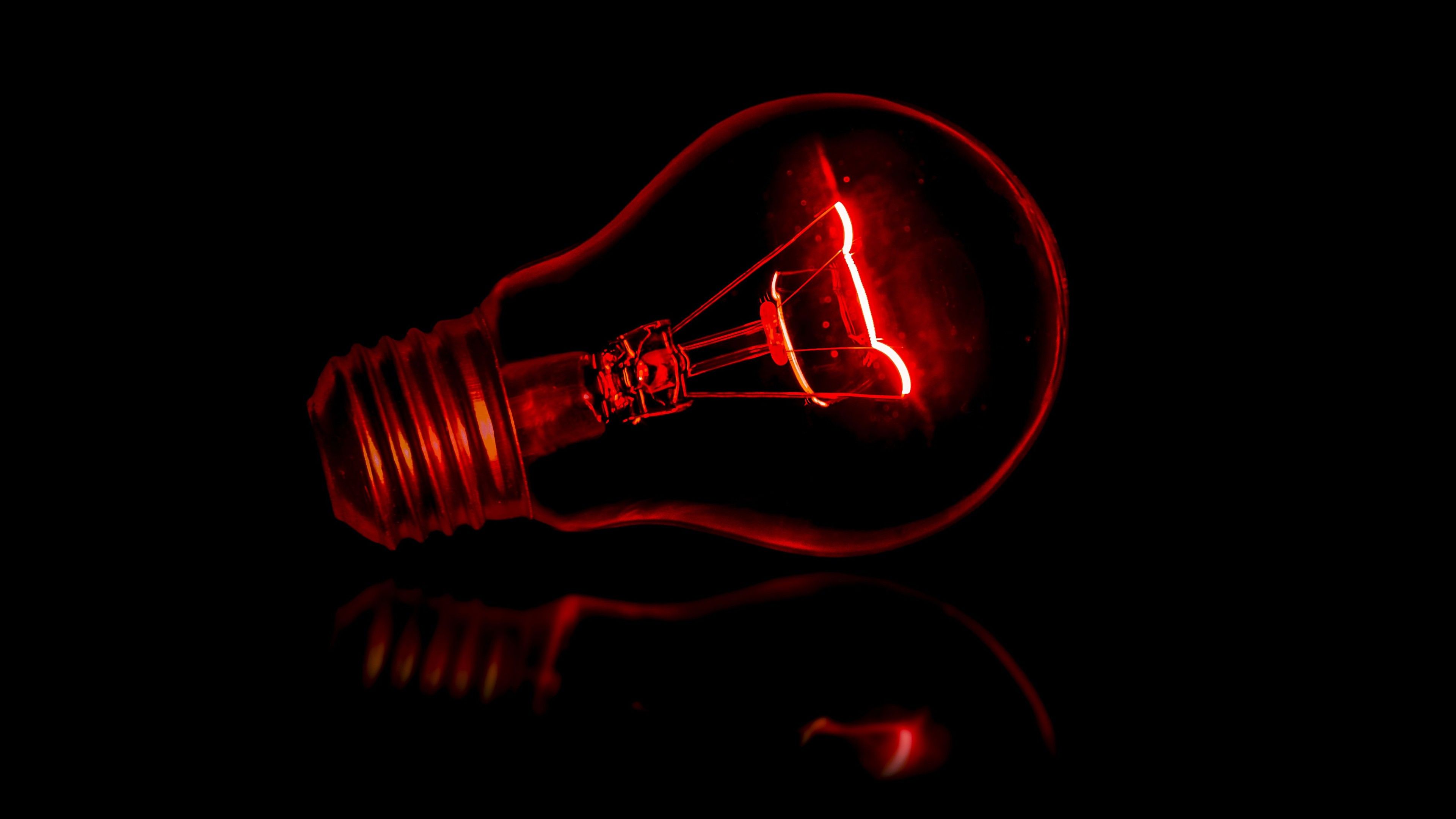 A red light bulb in a dark room. - Light red