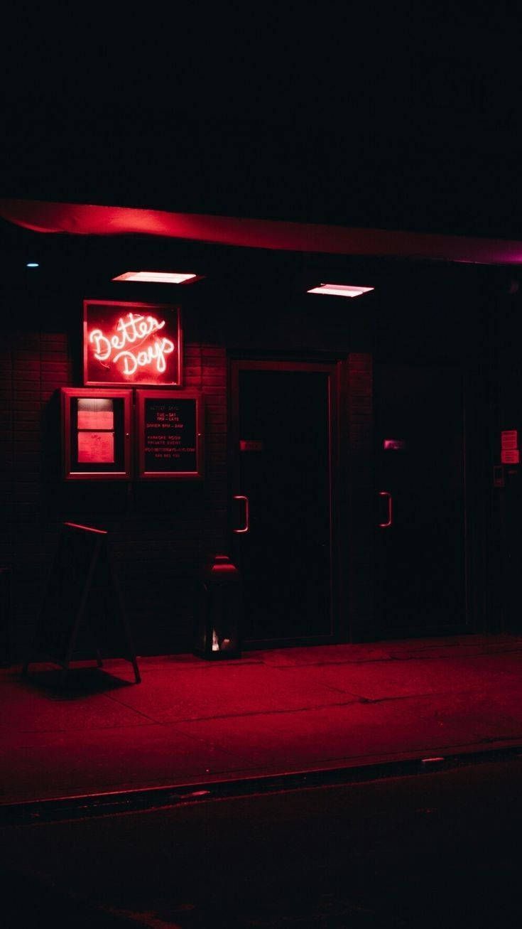 A red neon sign that says Better Days on a dark street - Light red