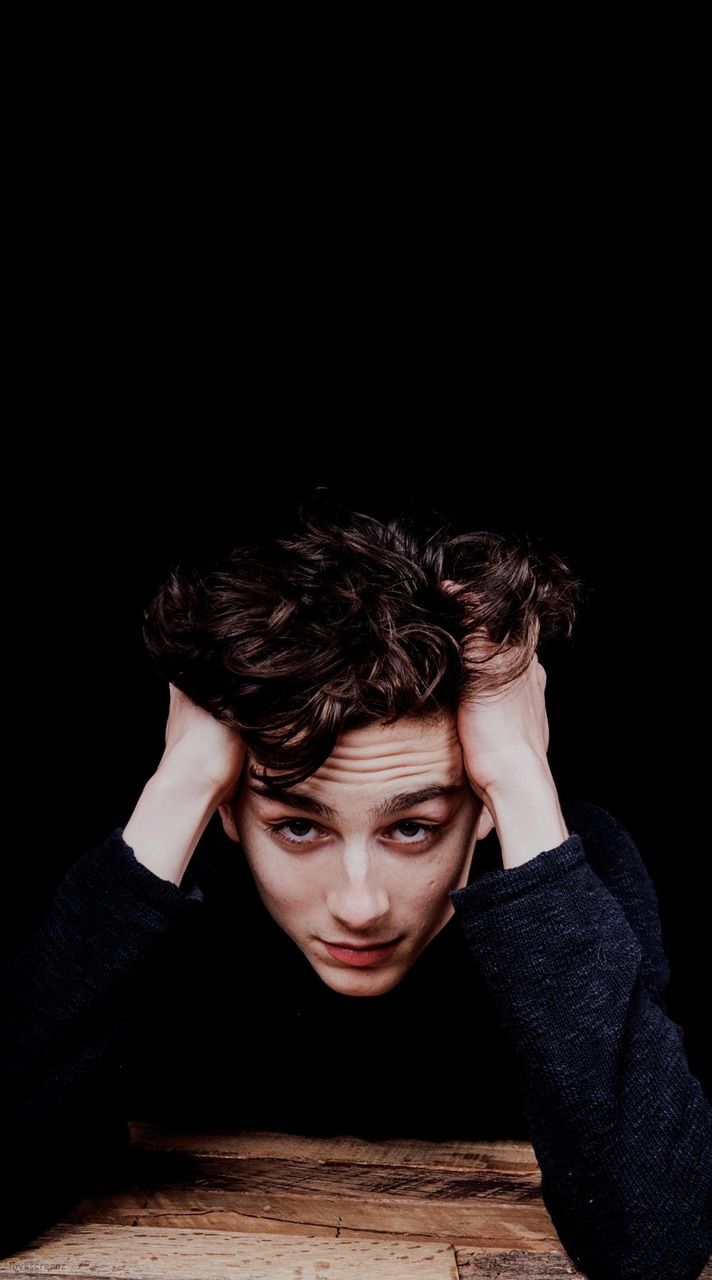 A young man with his head in hands - Timothee Chalamet