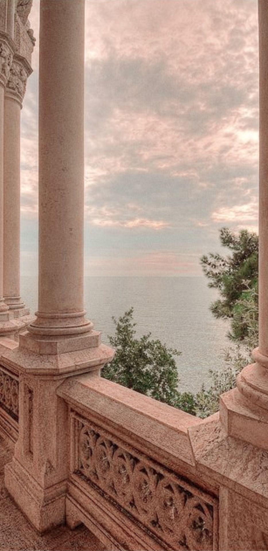 A balcony with columns and a view of the sea - Light academia