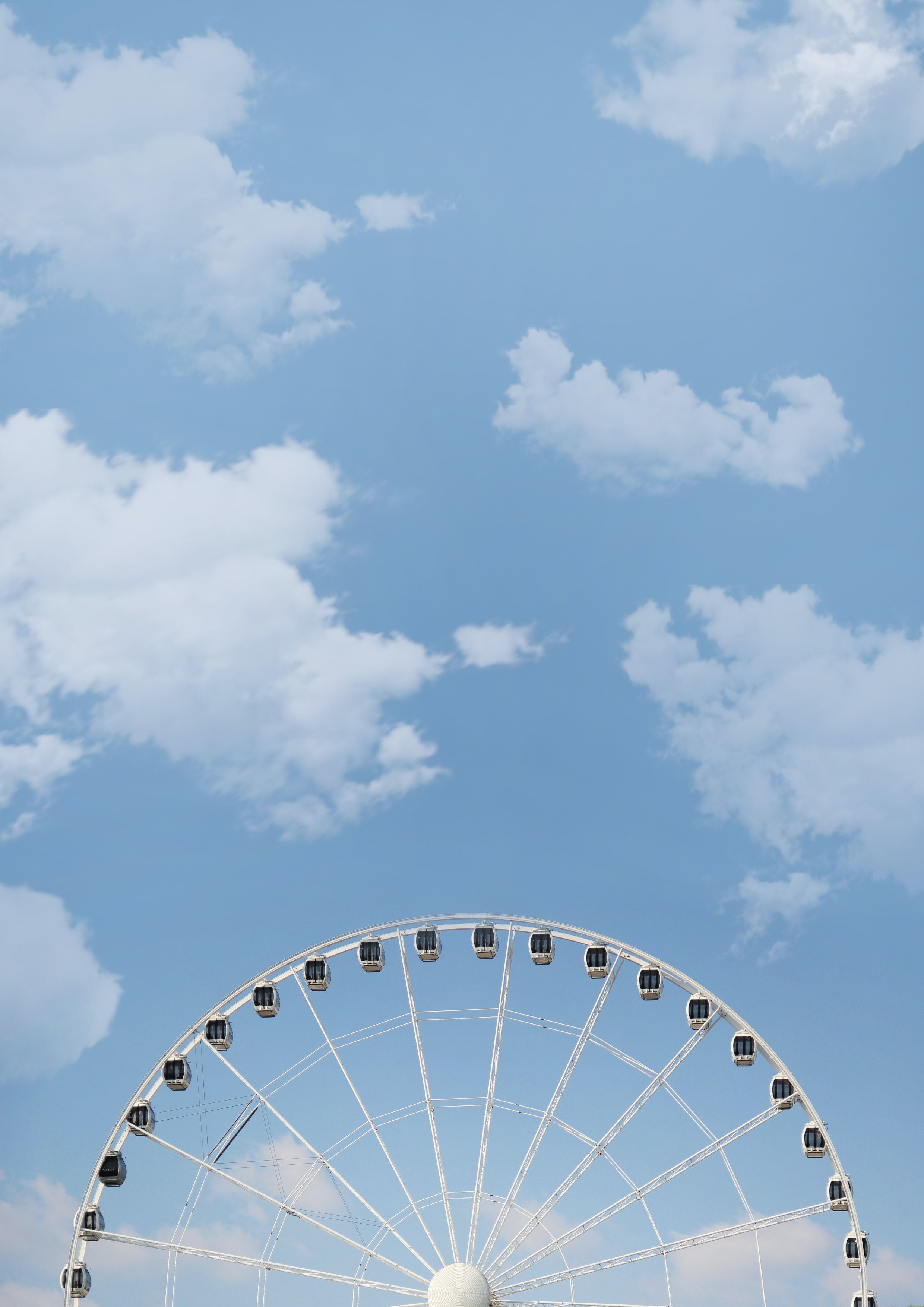 A ferris wheel with people on it in the sky - Blue, pastel blue, light blue