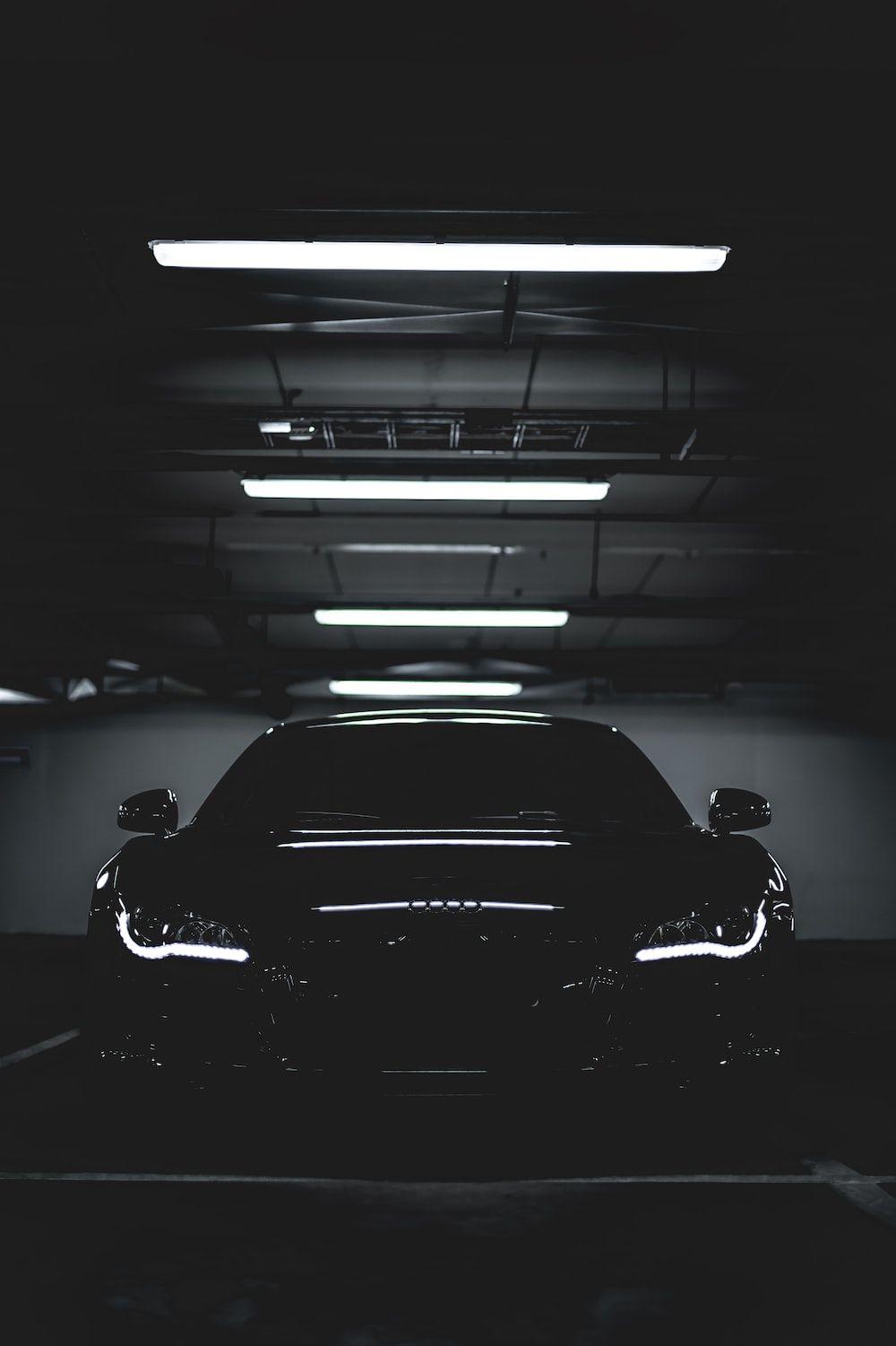 A car is parked in an empty parking garage - Cars