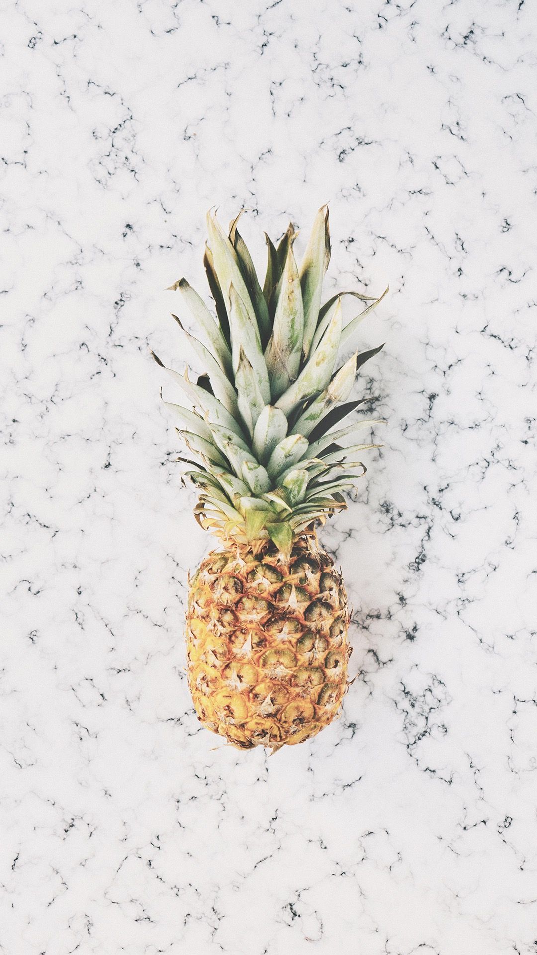 A pineapple sitting on top of marble - Pineapple