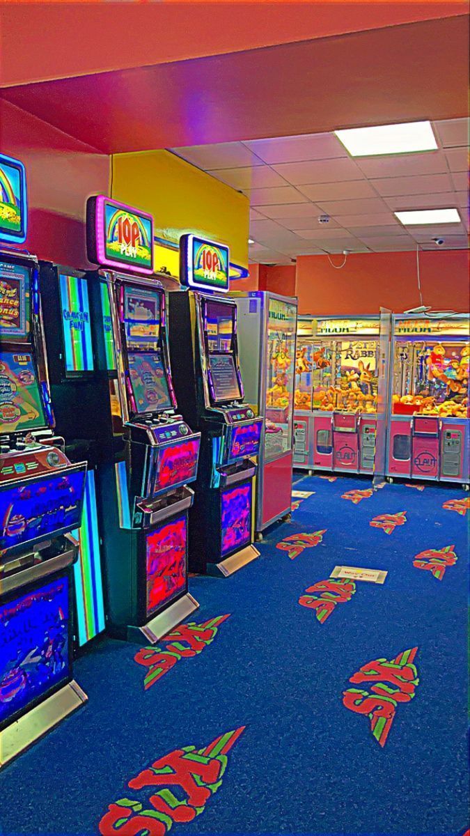 A row of slot machines and video games. - Arcade