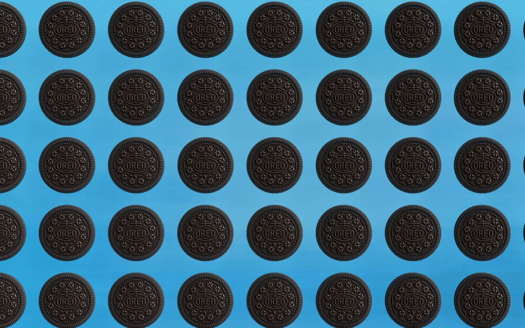 A blue background with rows of chocolate sandwich cookies. - Oreo