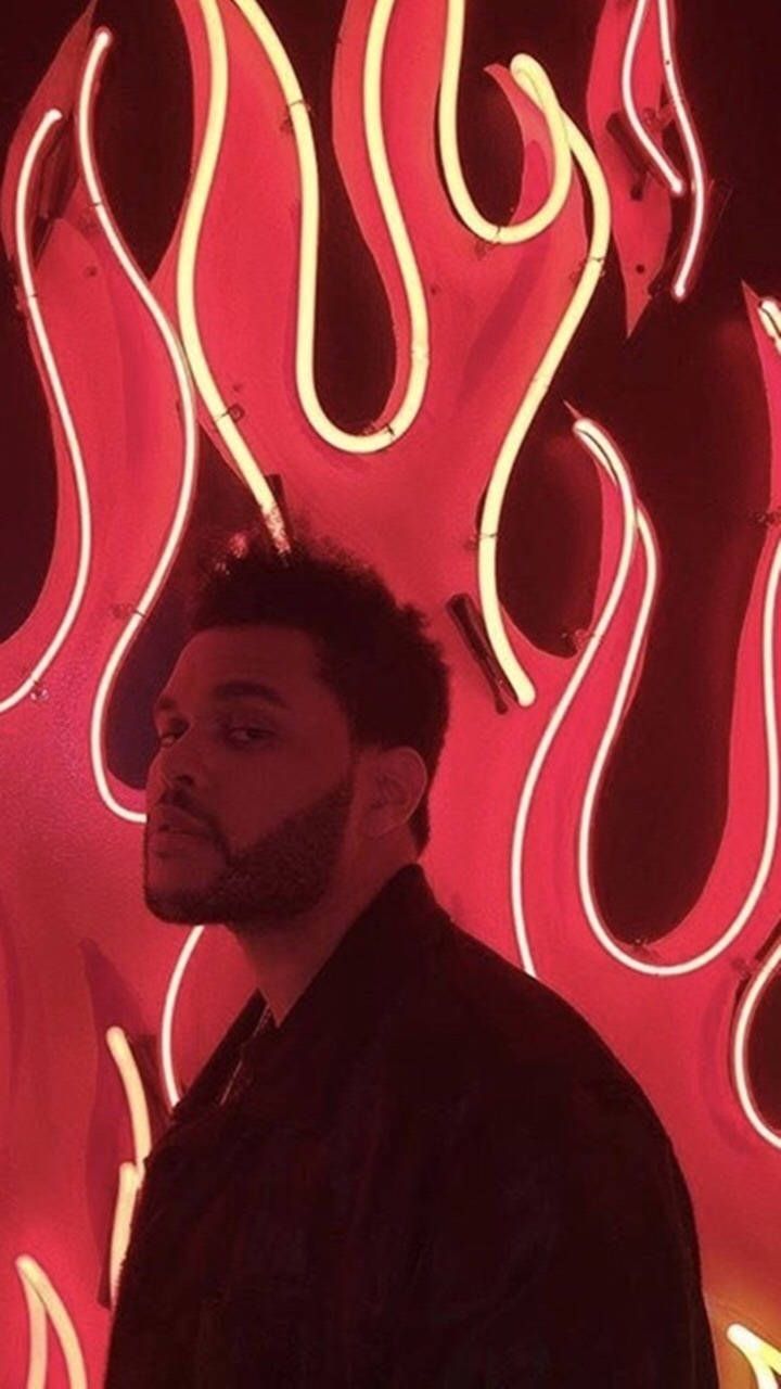 The Weeknd in front of a neon sign - The Weeknd