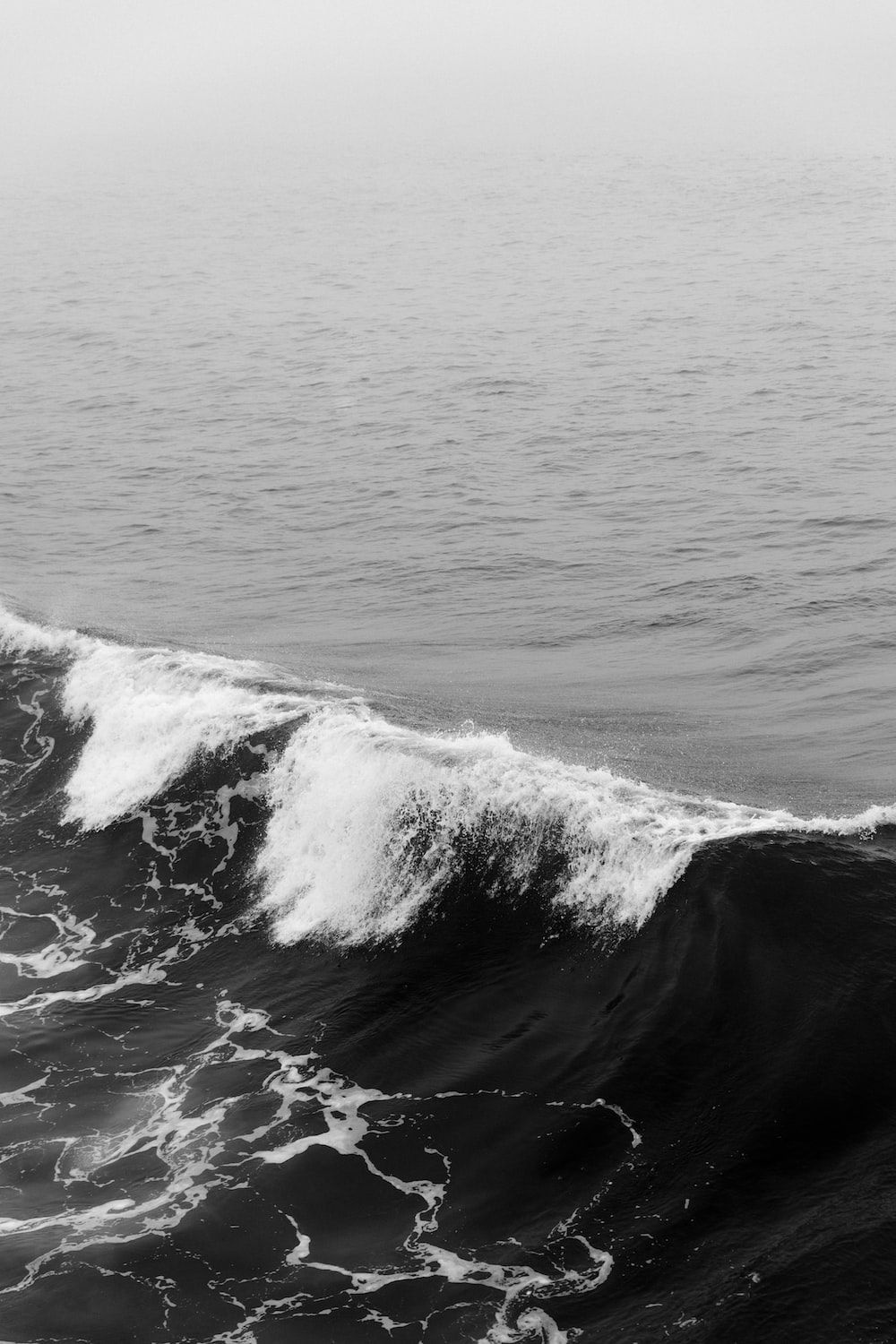 A black and white photo of a wave - Ocean