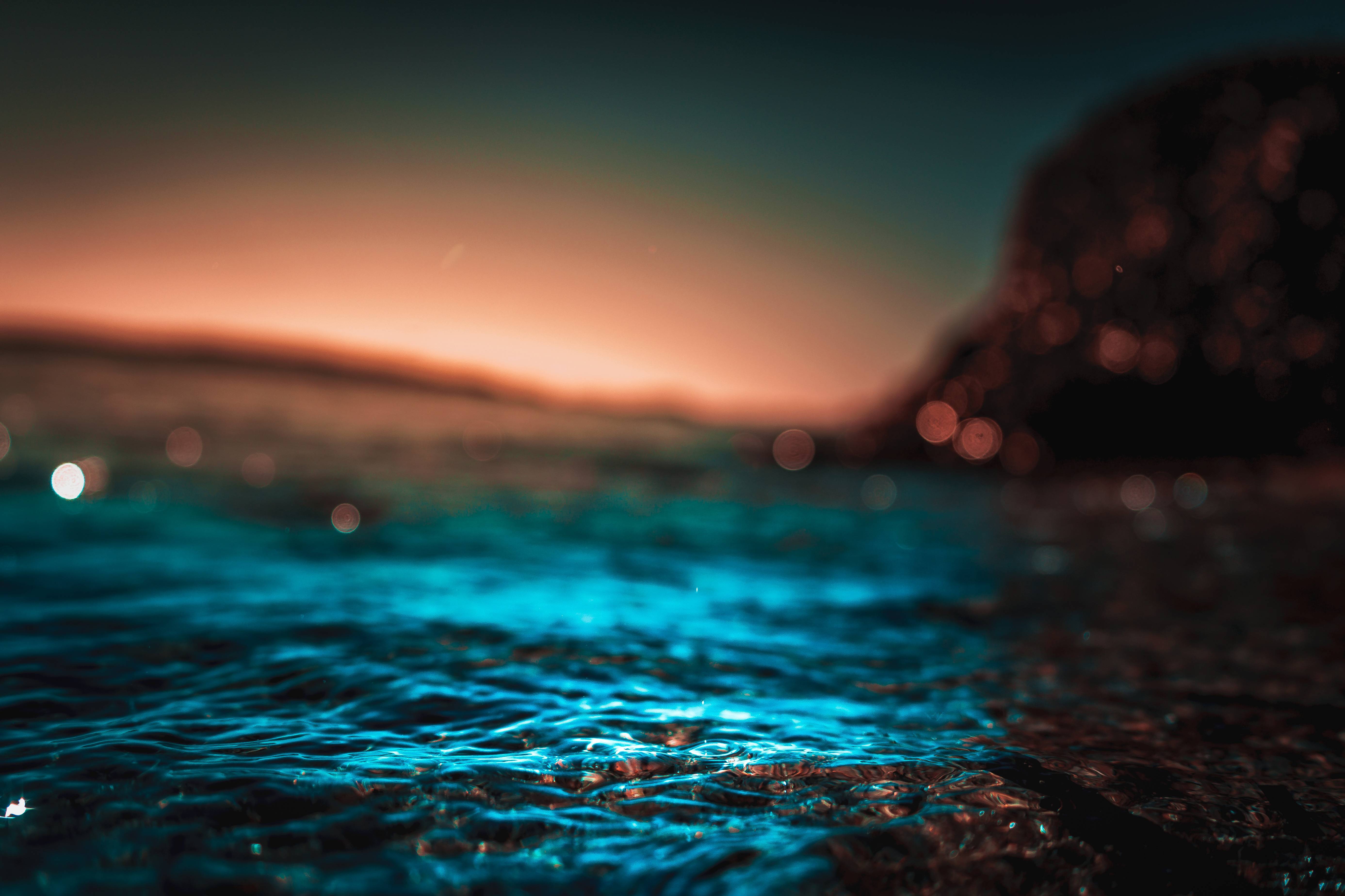 A close up of the water with a sunset in the background - Ocean, water