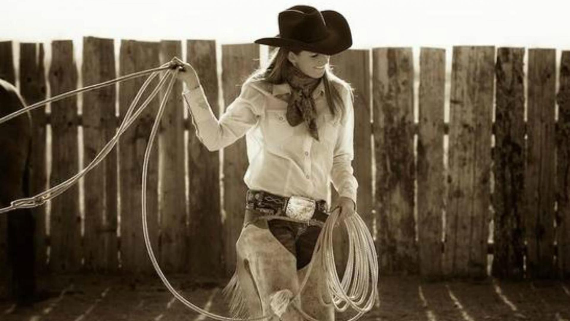 A woman in cowboy boots and hat with ropes - Cowgirl