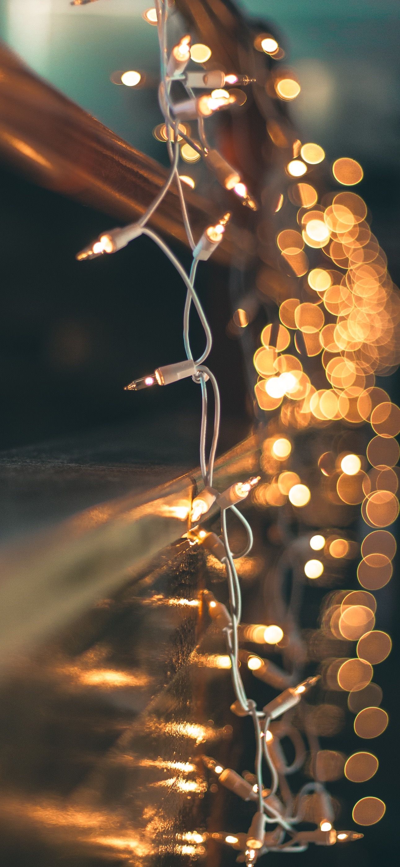 A string of lights wrapped around a wooden post. - Christmas lights, wedding