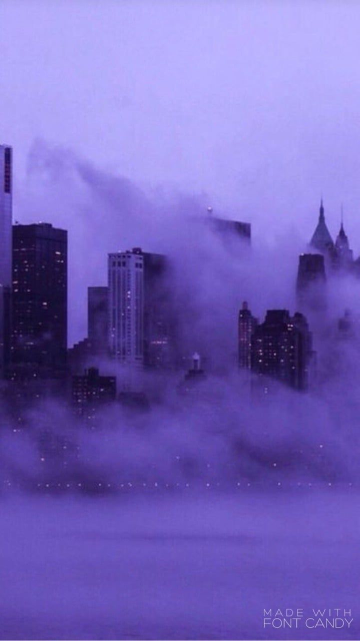 A city skyline with skyscrapers and fog. - Purple
