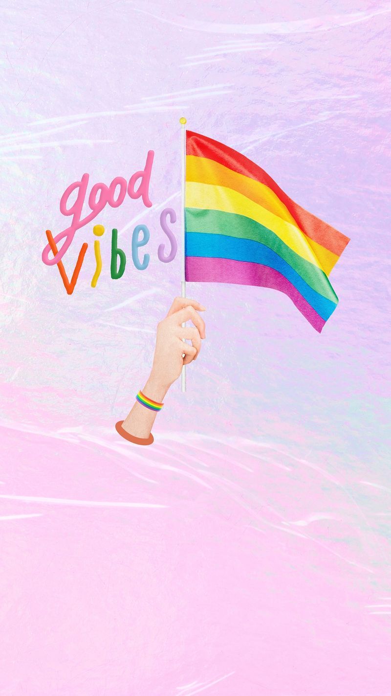 A rainbow flag is being held up by someone - Pride, rainbows, LGBT, bisexual