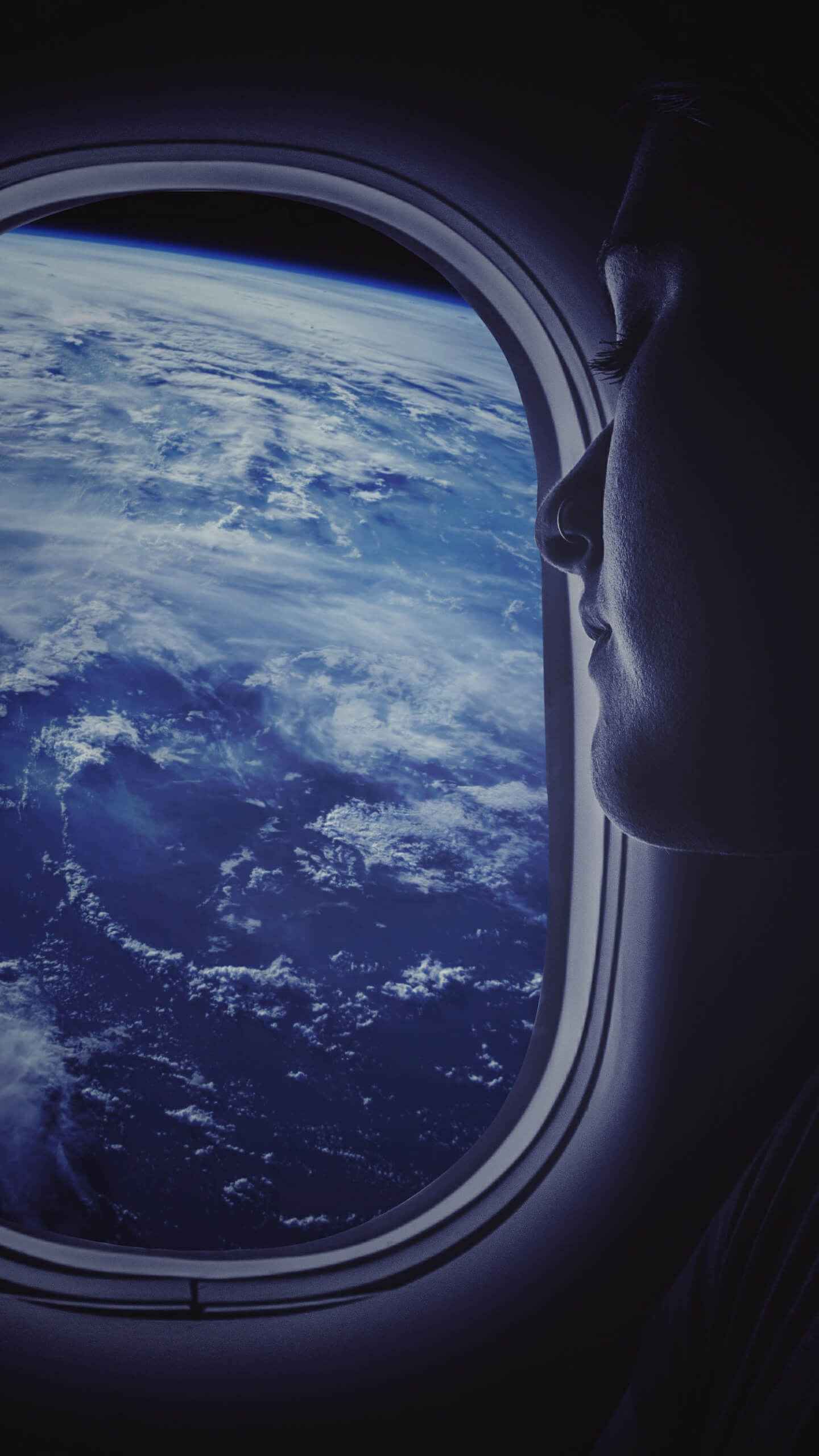 Woman looking out of a plane window - Travel