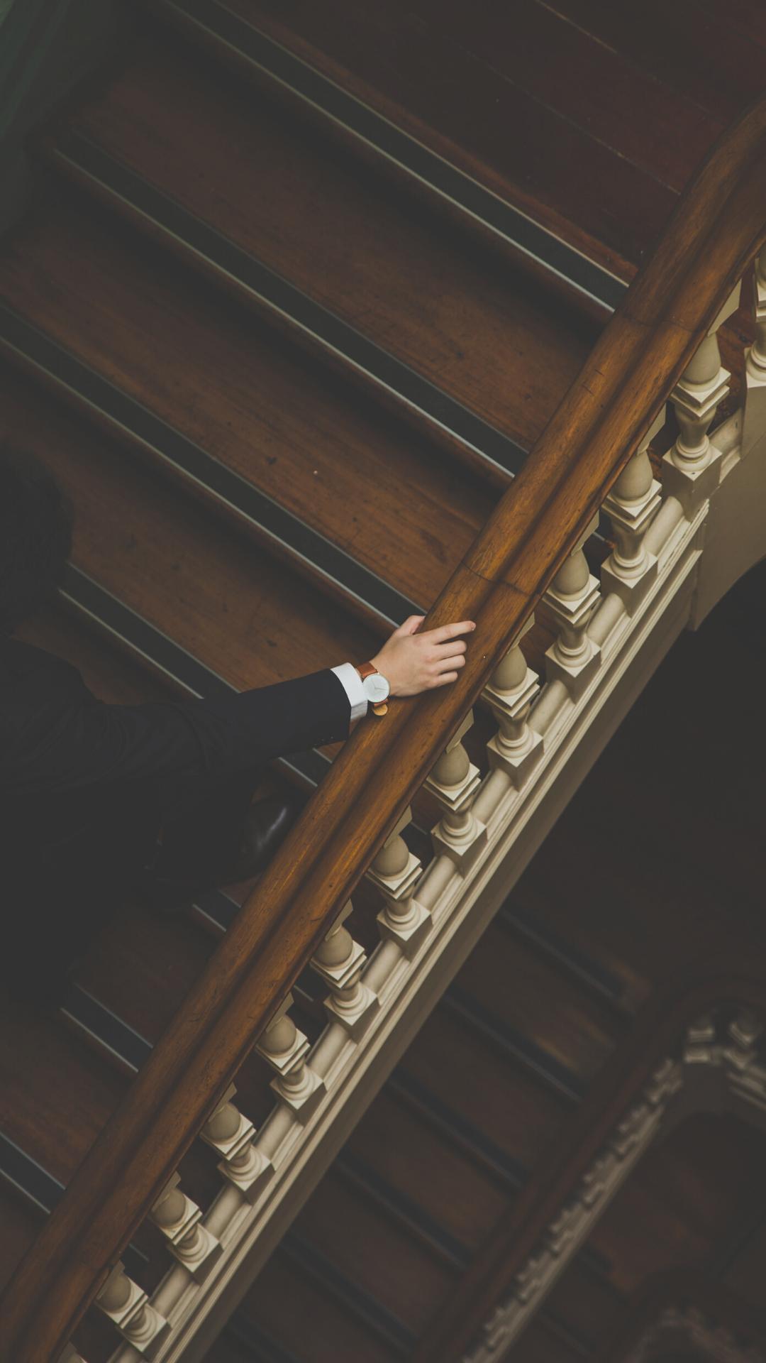 A man in a suit walking down a staircase - Library