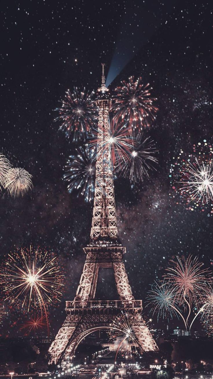 Fireworks light up the sky behind the Eiffel Tower in Paris. - New Year