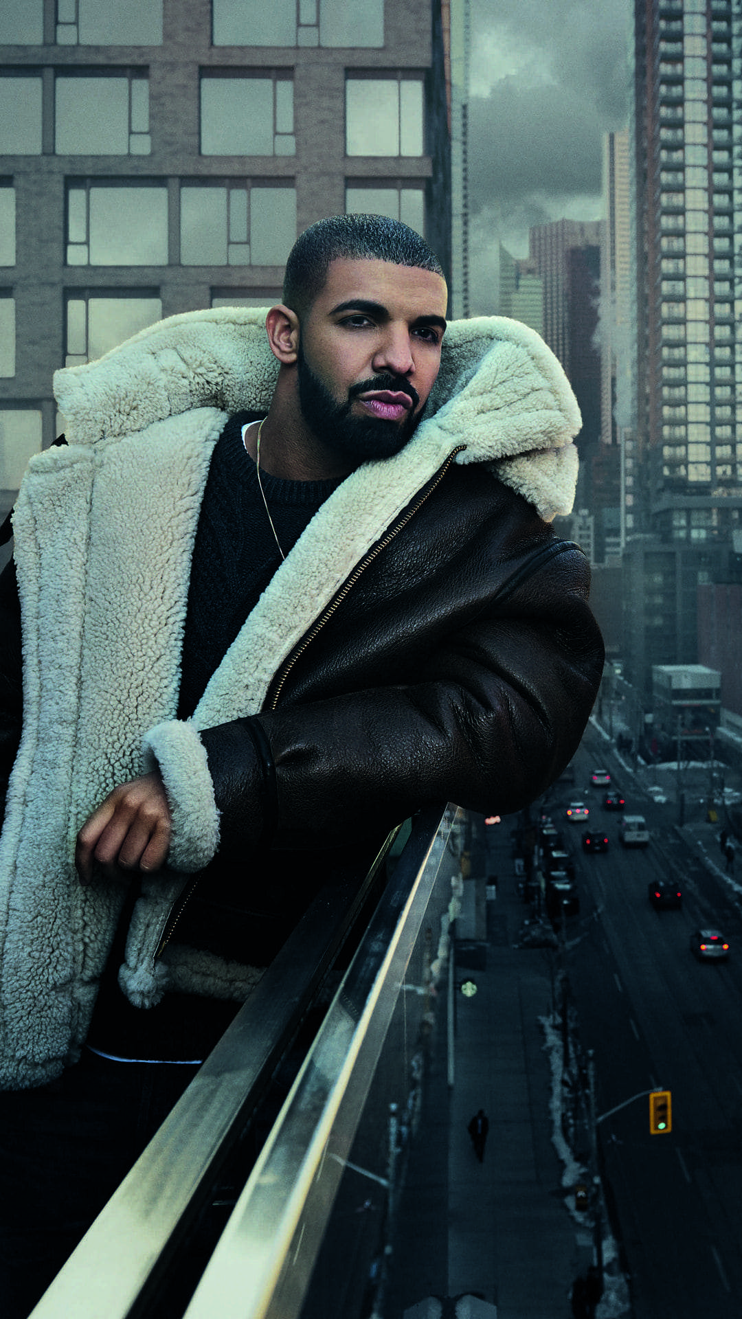 Drake standing on a balcony in a jacket - Drake