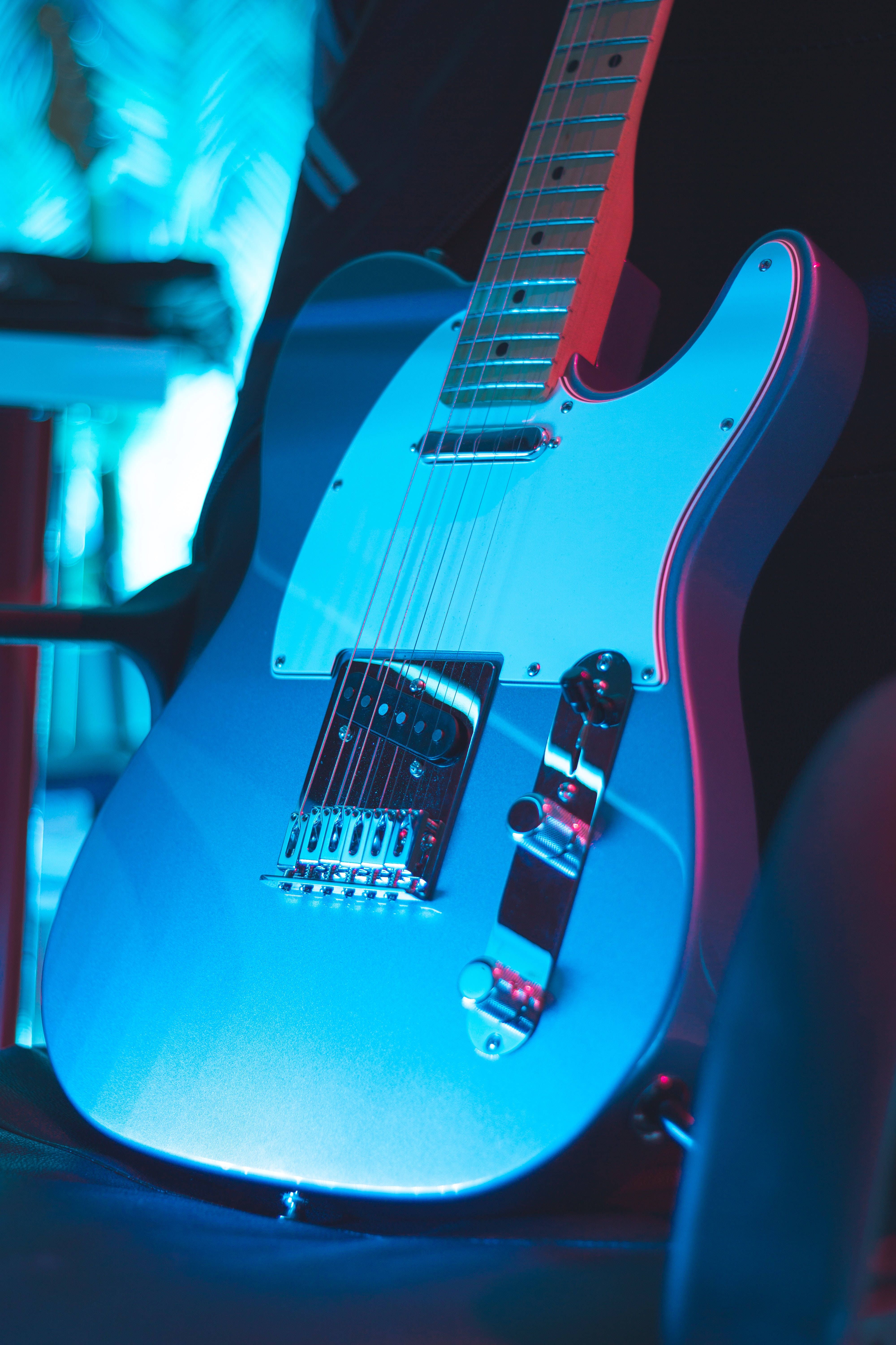 A blue electric guitar sitting on top of something - Guitar
