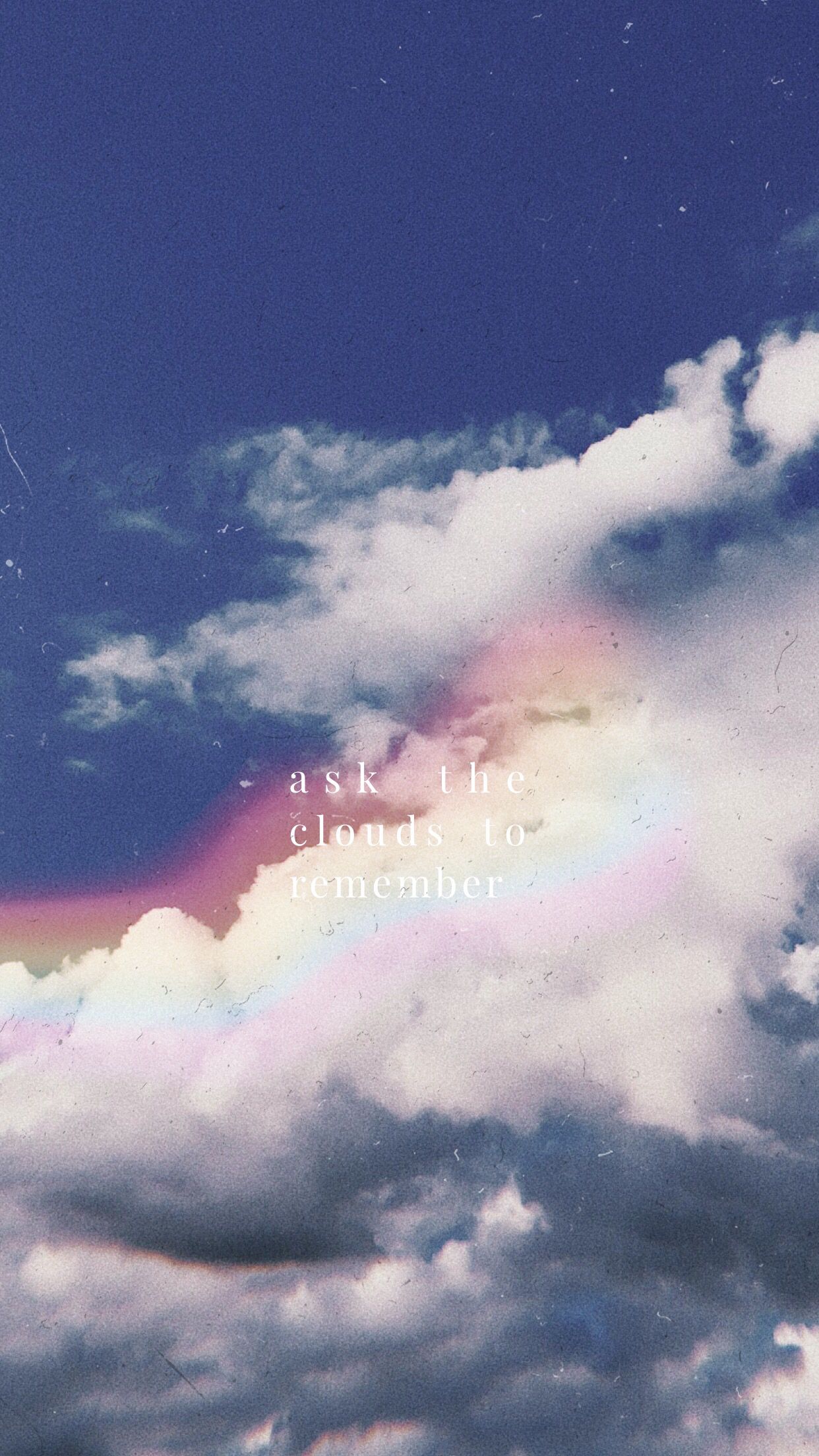 Aesthetic image of a cloudy sky with a rainbow and the words 