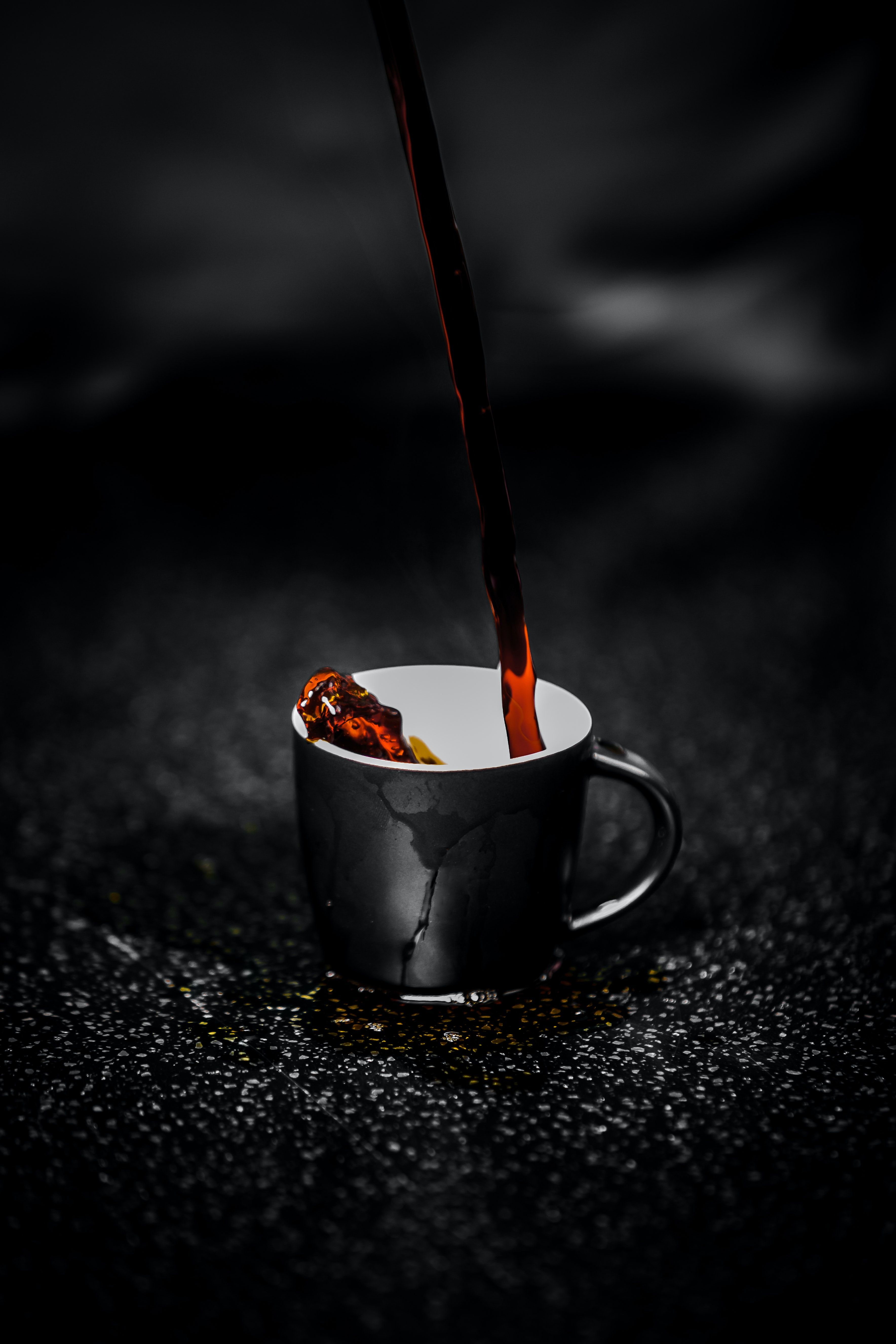 A black cup with a crack in it with coffee being poured into it. - Magic